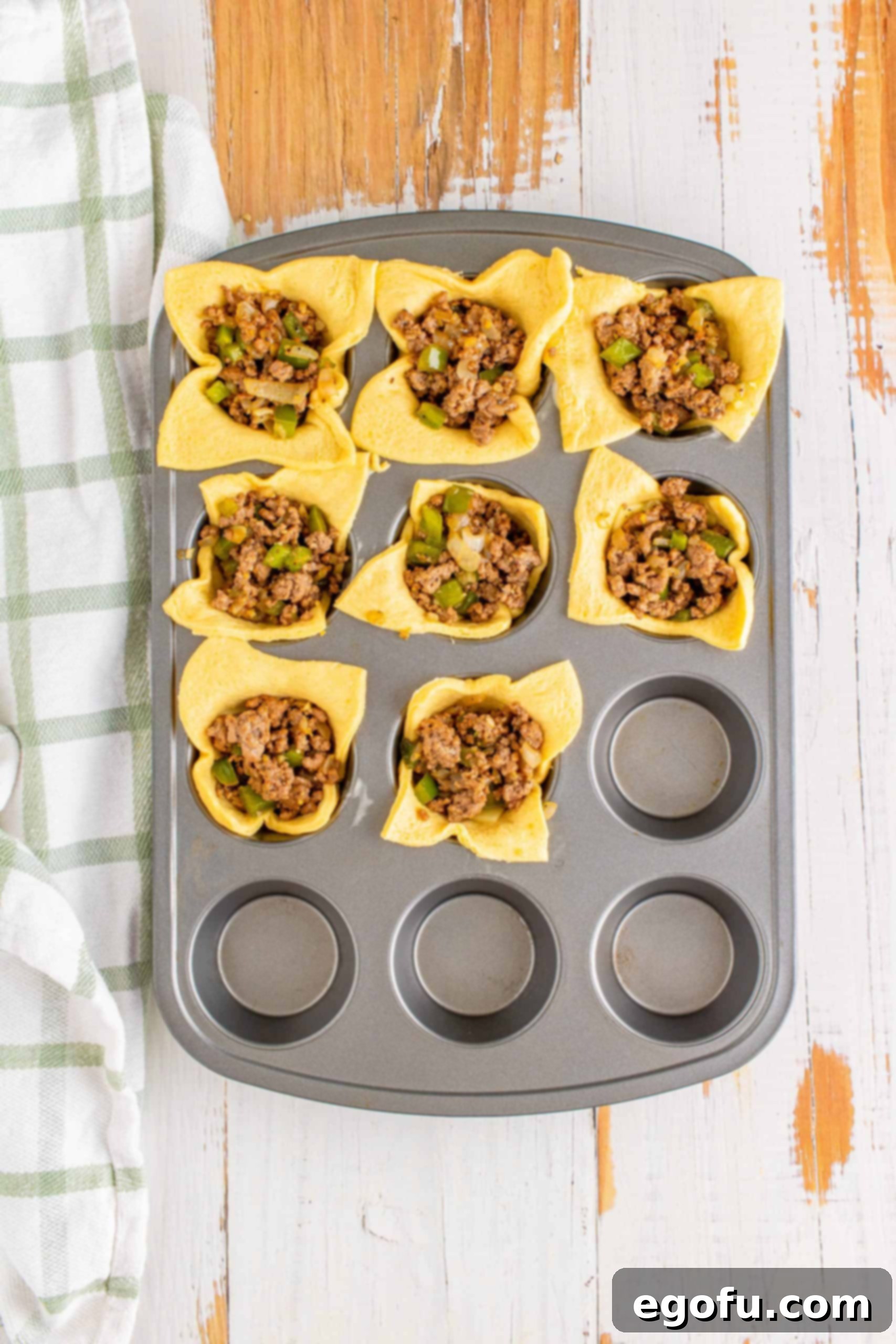 Philly Cheesesteak Poppers 9 Ground beef mixture spooned over the cheese in the muffin tin.