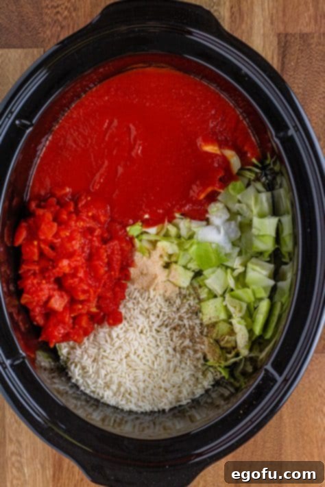 ingredients for unstuffed cabbage rolls added to slow cooker.