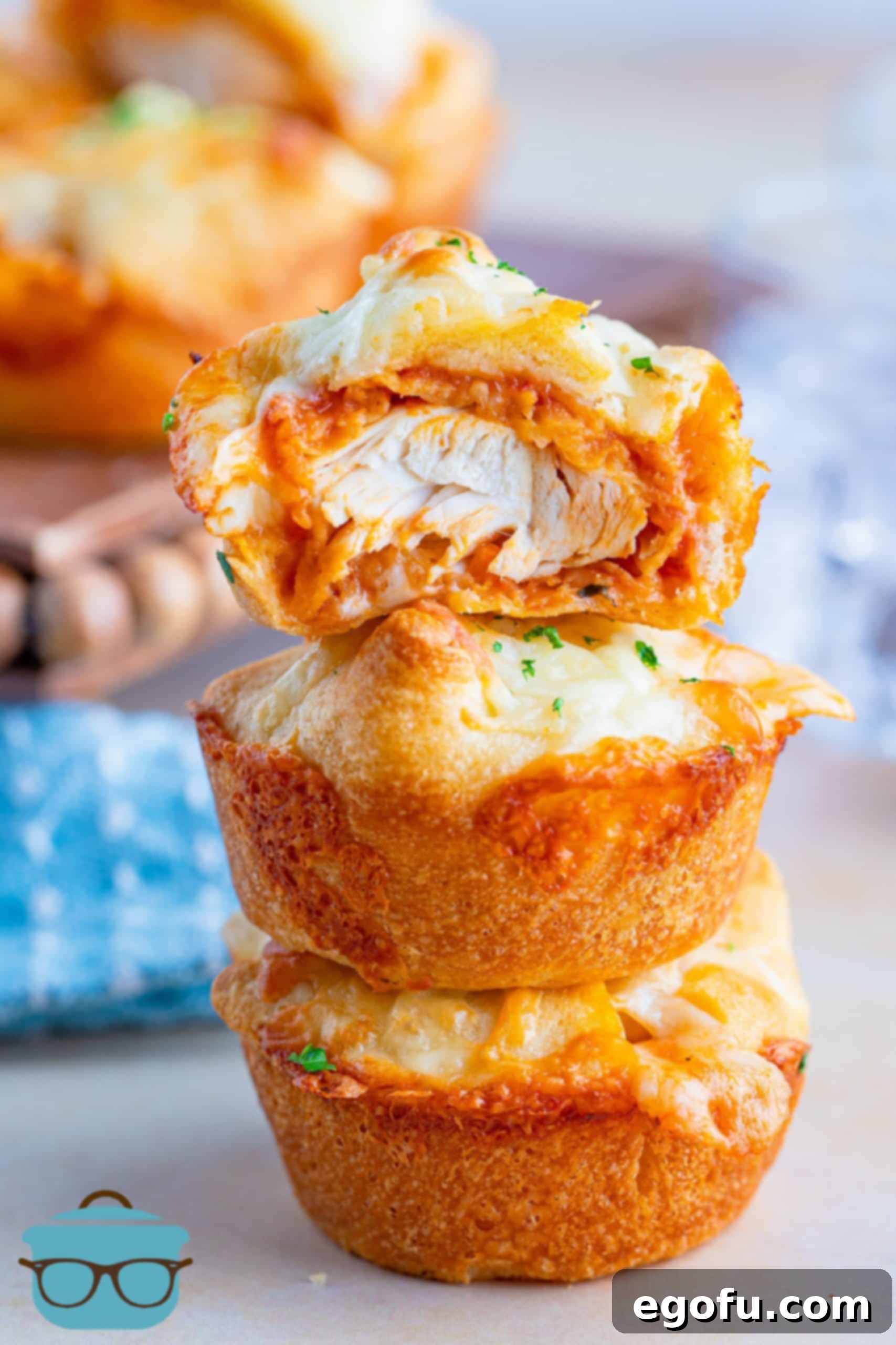 A stack of golden chicken parmesan cups, with one cut open to show the delicious layers of chicken, sauce, and melted cheese inside.