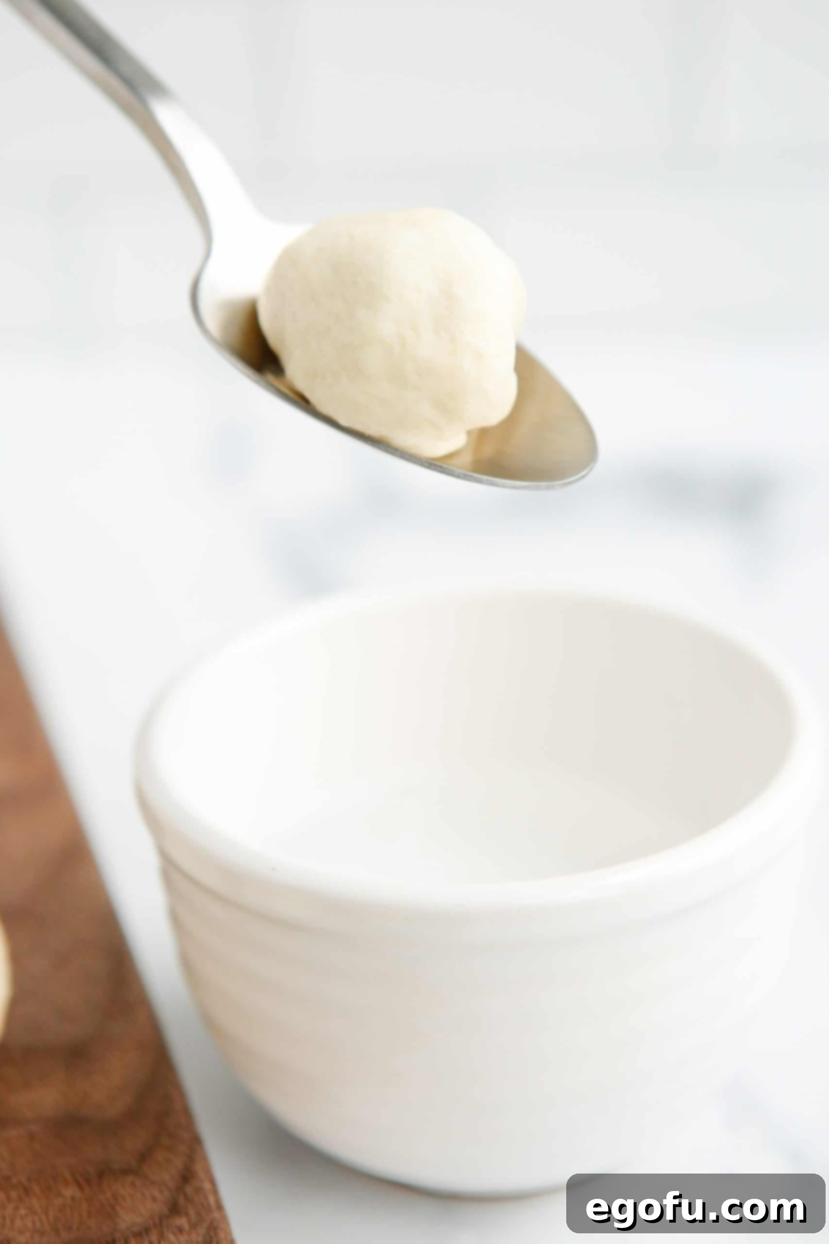 Stuffed Pretzel Bites being dipped into the baking soda and water mixture.