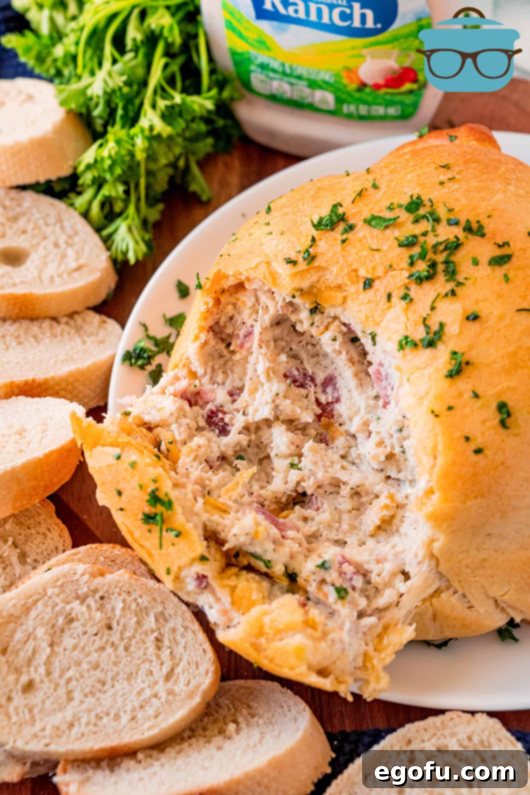 A golden-brown Crack Chicken Ball on a serving platter, revealing its delicious chicken, bacon, ranch, and cheese filling beneath the crescent dough. Perfect for parties and gatherings.