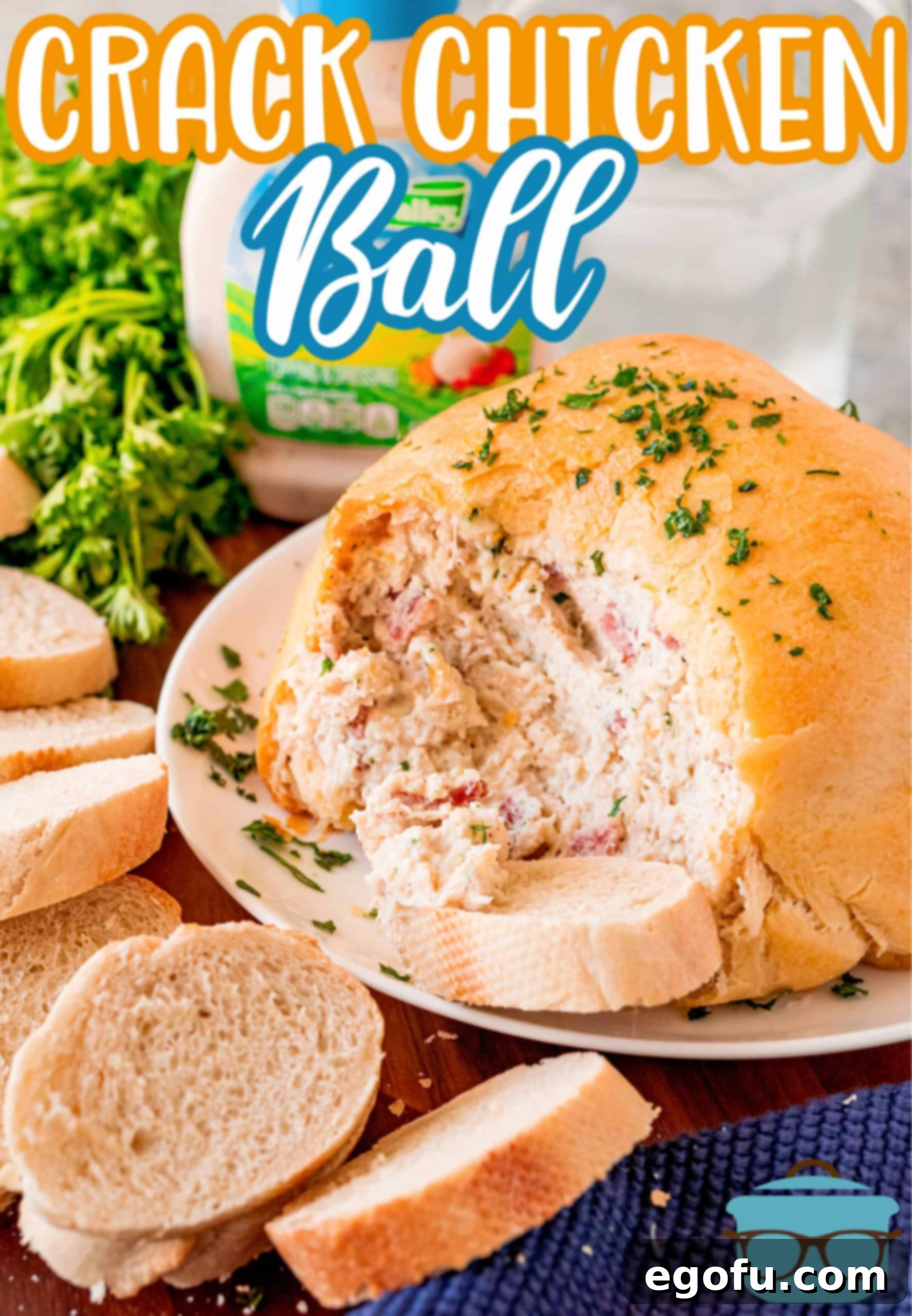 A freshly baked Crack Chicken Ball, sliced open to reveal the rich, creamy chicken, bacon, ranch, and cheese filling, served on a plate with crusty bread.