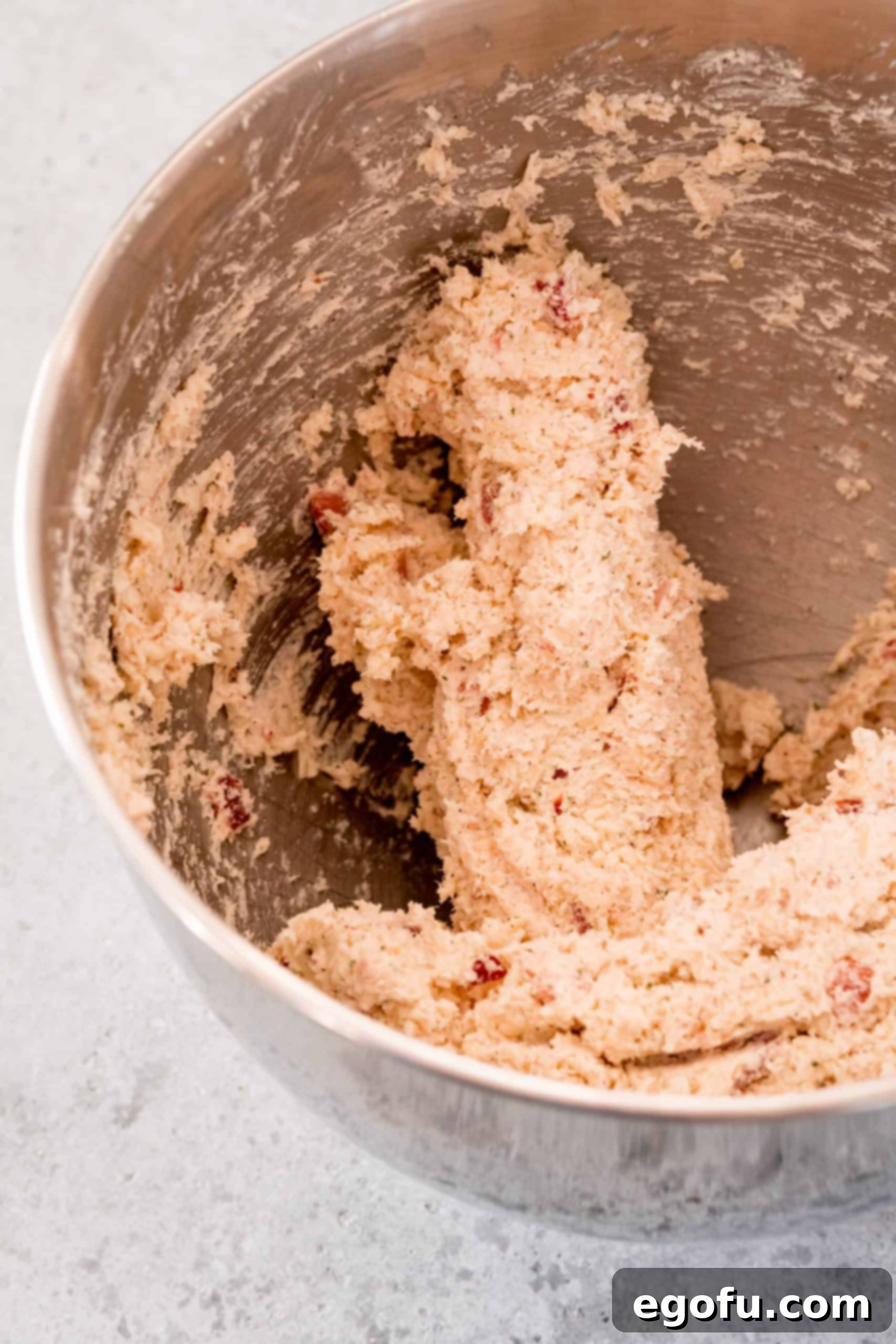 The complete Crack Chicken Ball mixture, featuring chicken, bacon, ranch, and various cheeses, perfectly combined and ready for shaping in a stand mixer bowl.