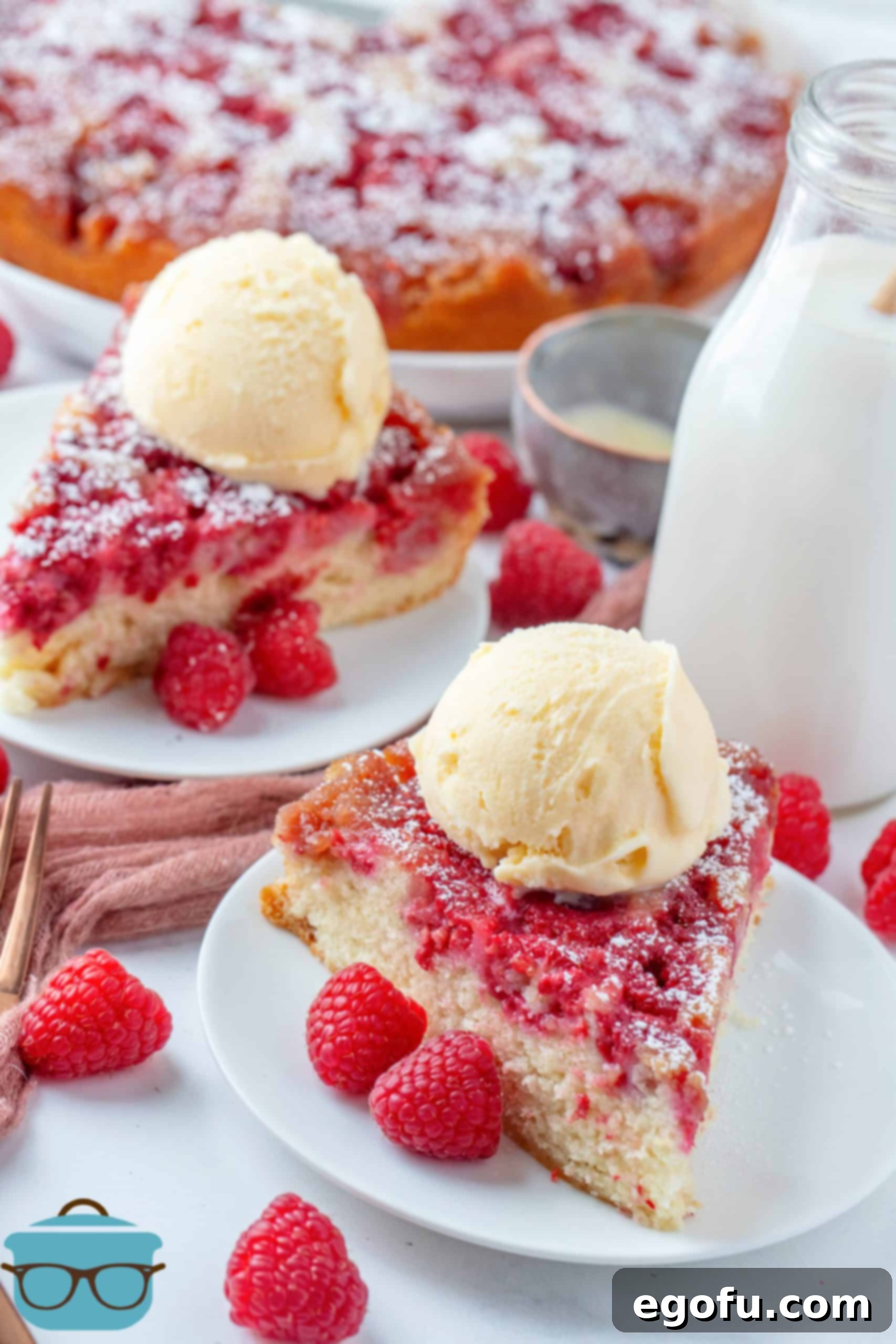 Crimson Raspberry Flip Cake 19 Two slices of Raspberry Upside Down Cake on white plates topped with ice cream.