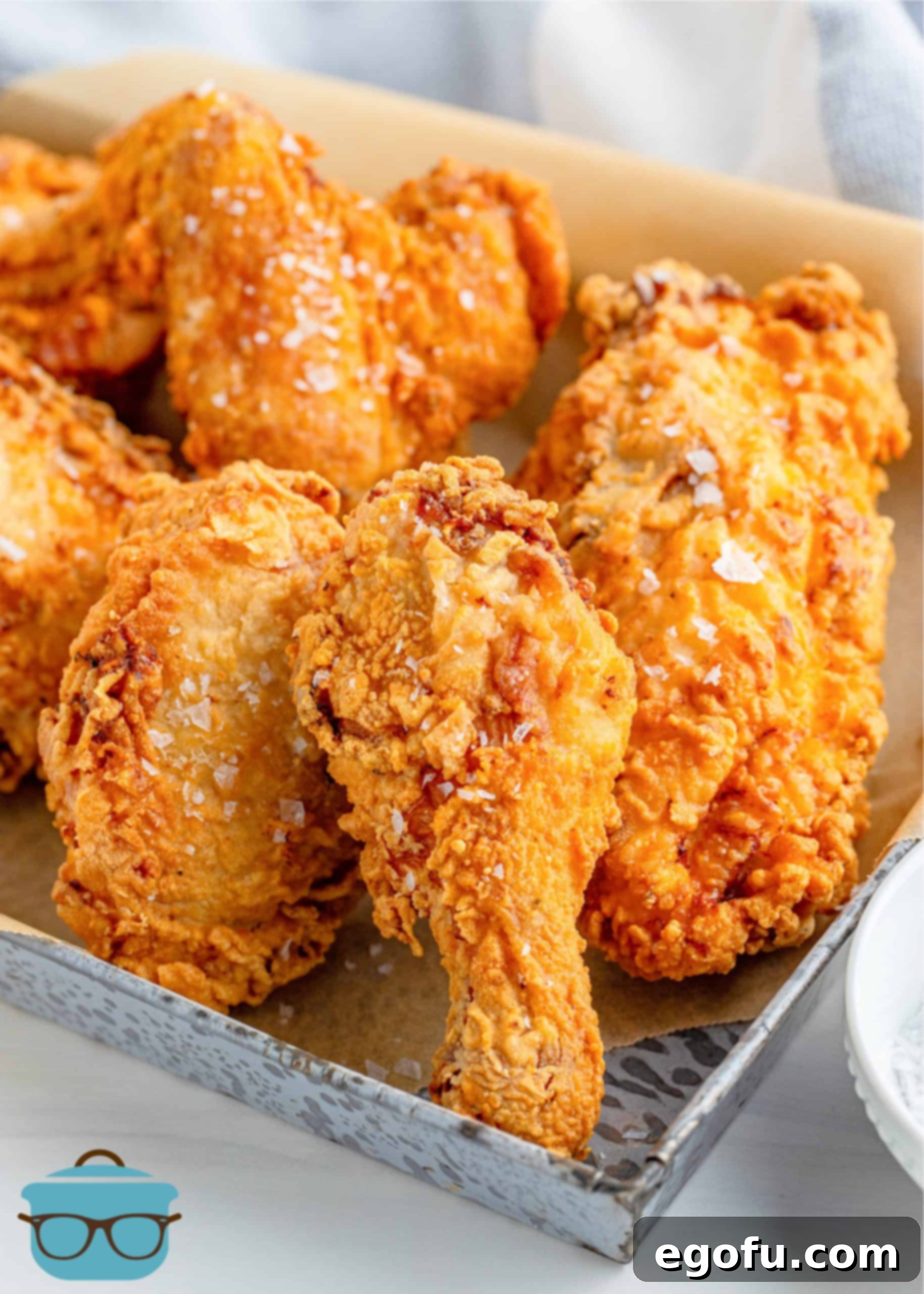 The Best Southern Fried Chicken laid out on a parchment paper lined metal tray.