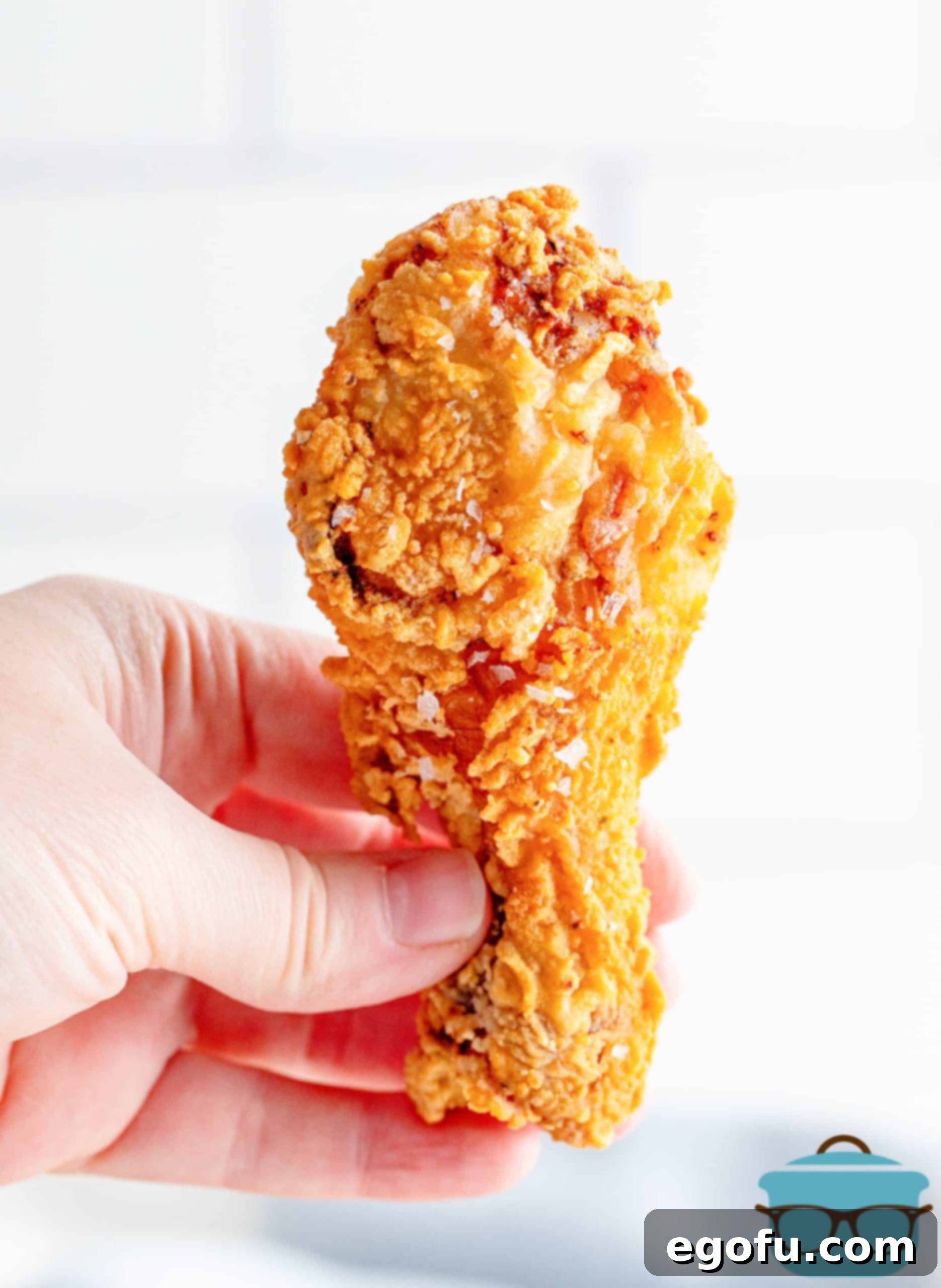 Hand holding a leg piece of Southern Fried Chicken