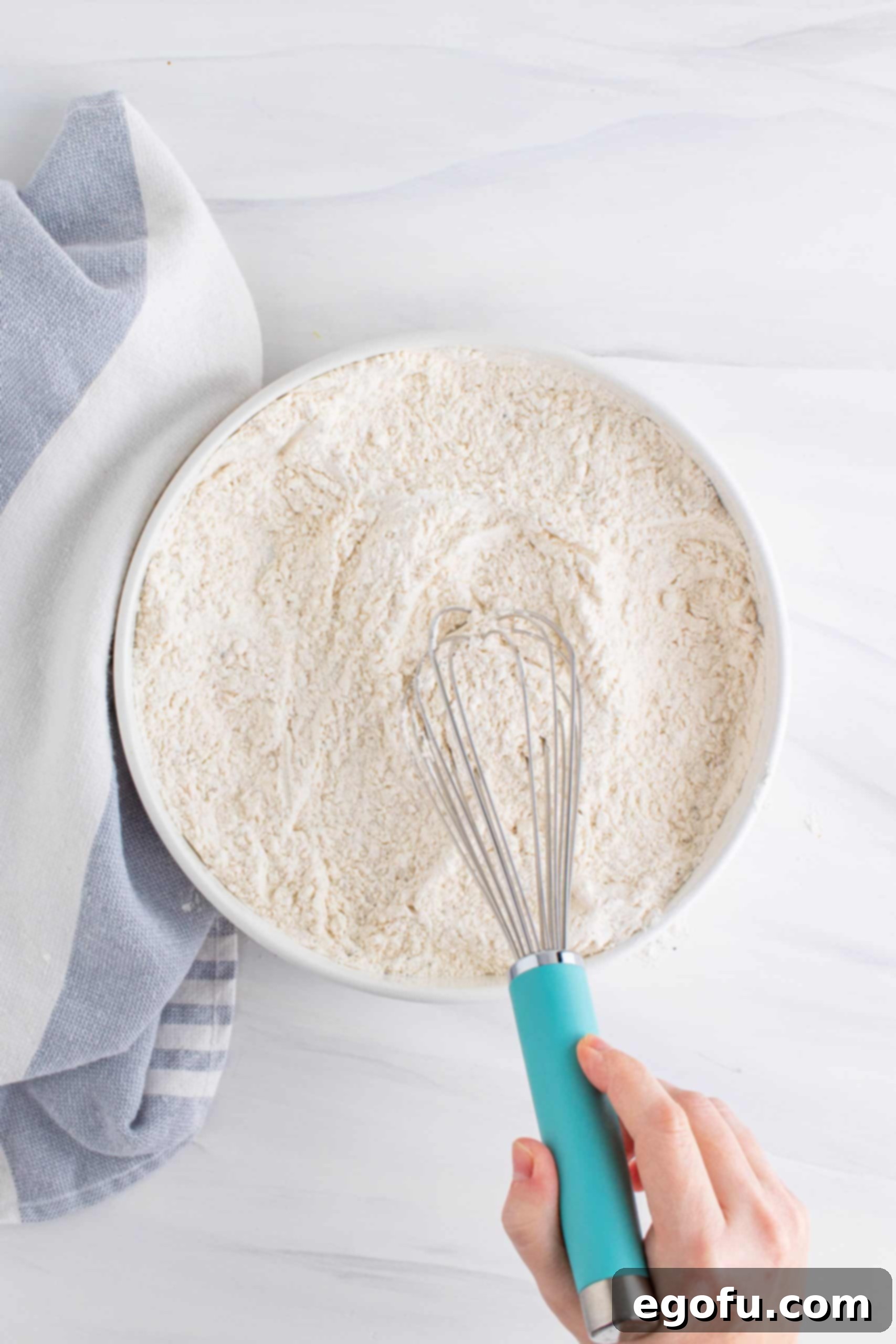Whisk mixing up flour mixture in a bowl.