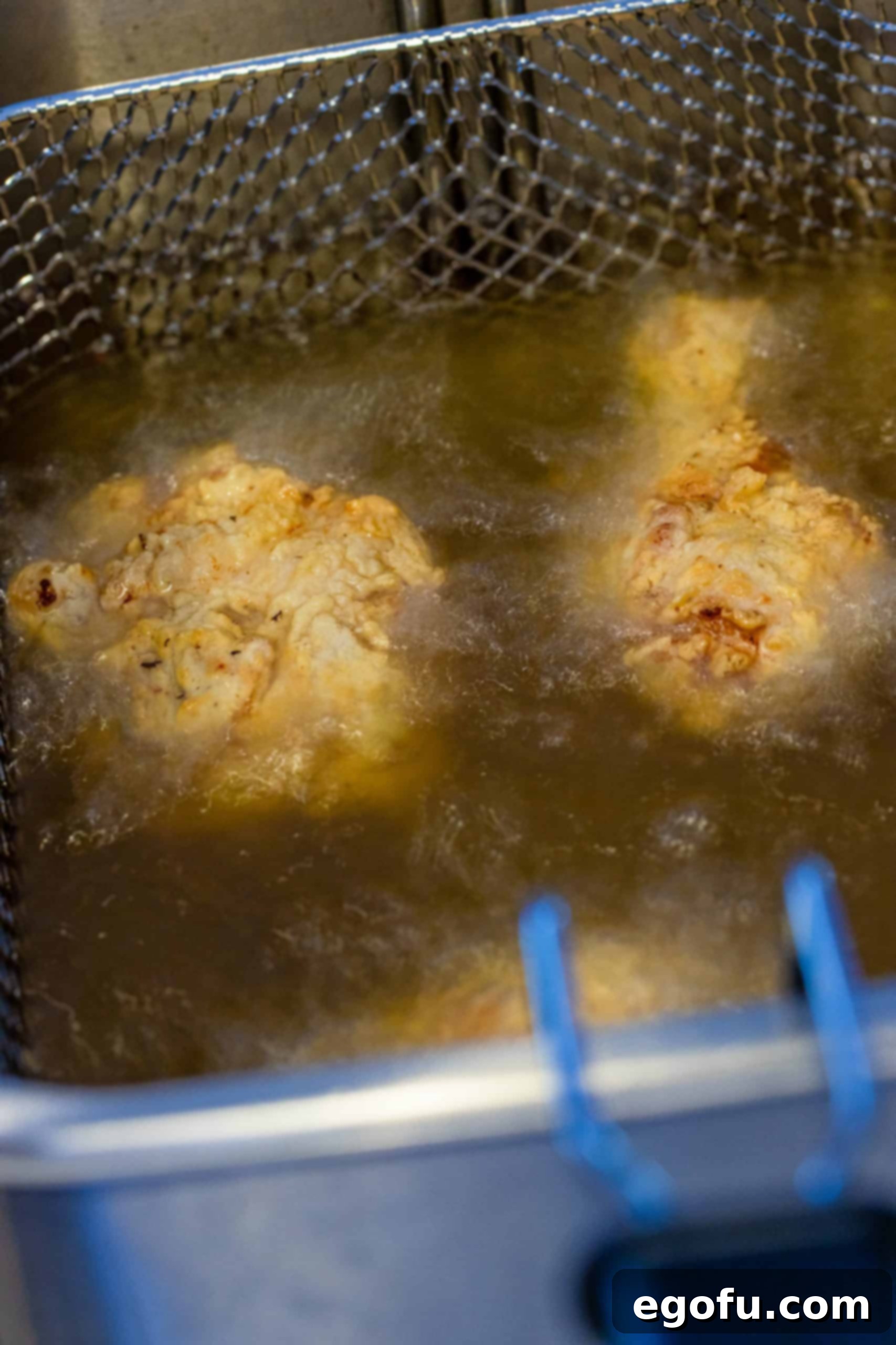 Chicken in frying oil.