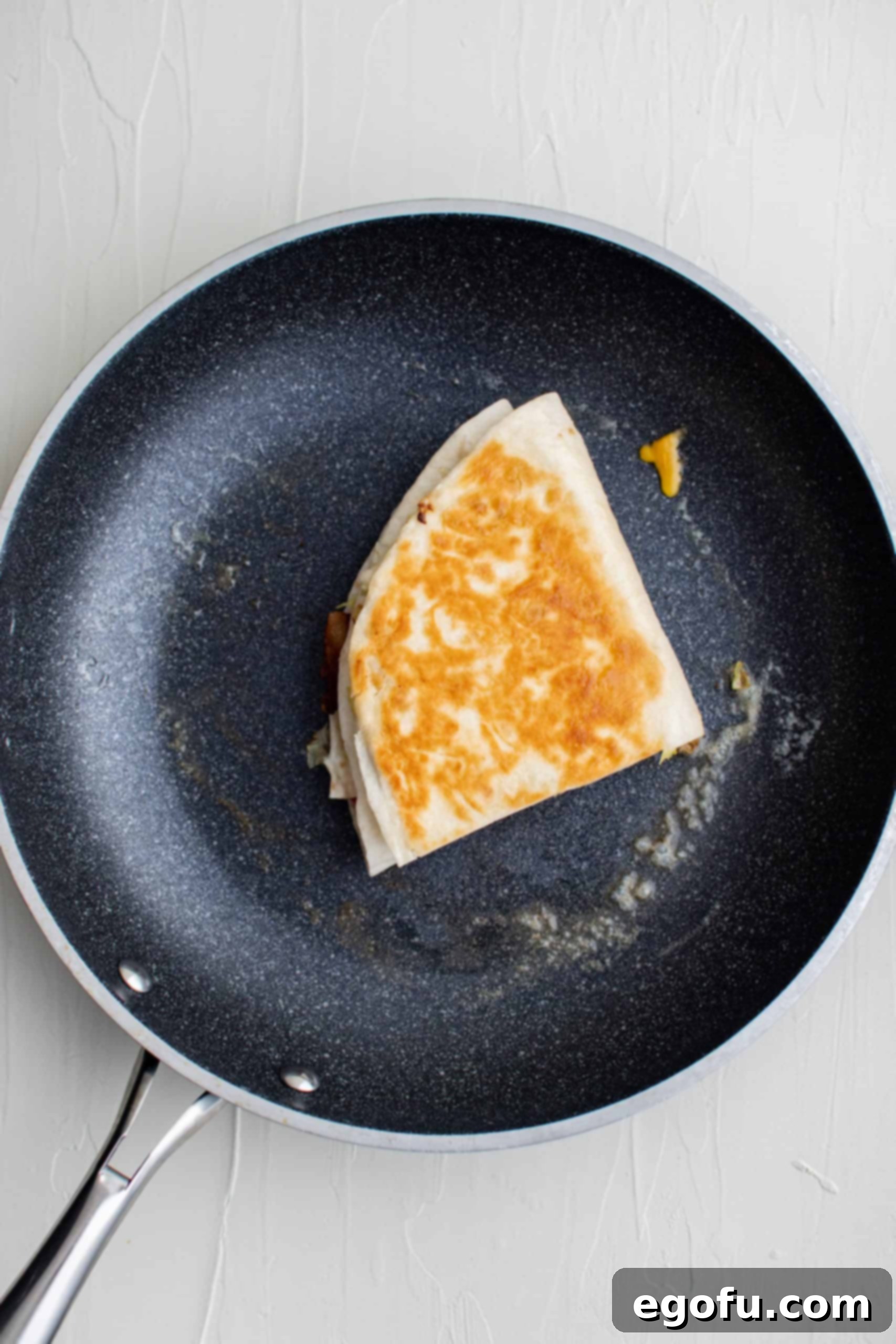 Finished browned BLT Quesadilla in pan, perfectly golden and crispy.