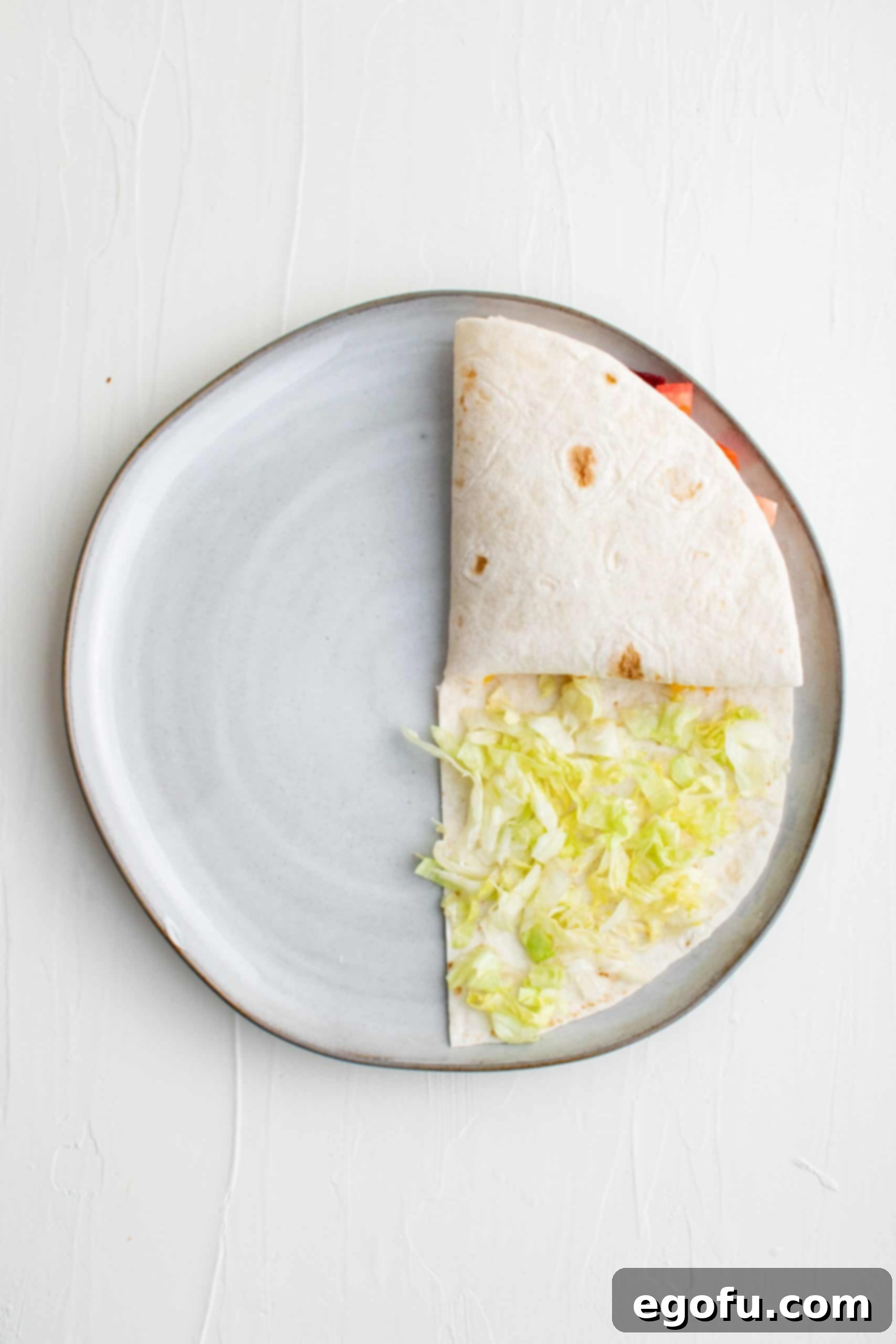 The second fold: folded bacon and tomato section flipped onto the cheese quadrant.