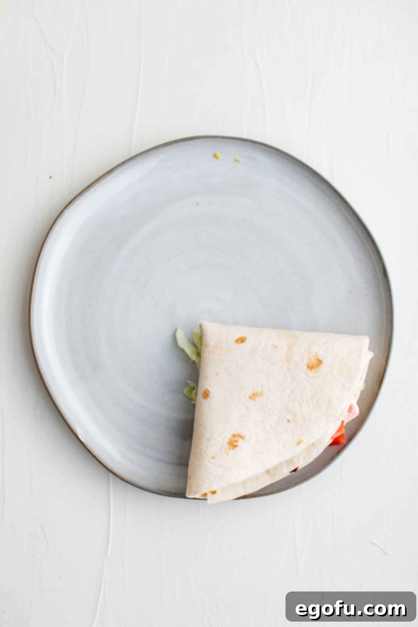 The final fold: the entire BLT Quesadilla folded into a compact triangle, ready for cooking.