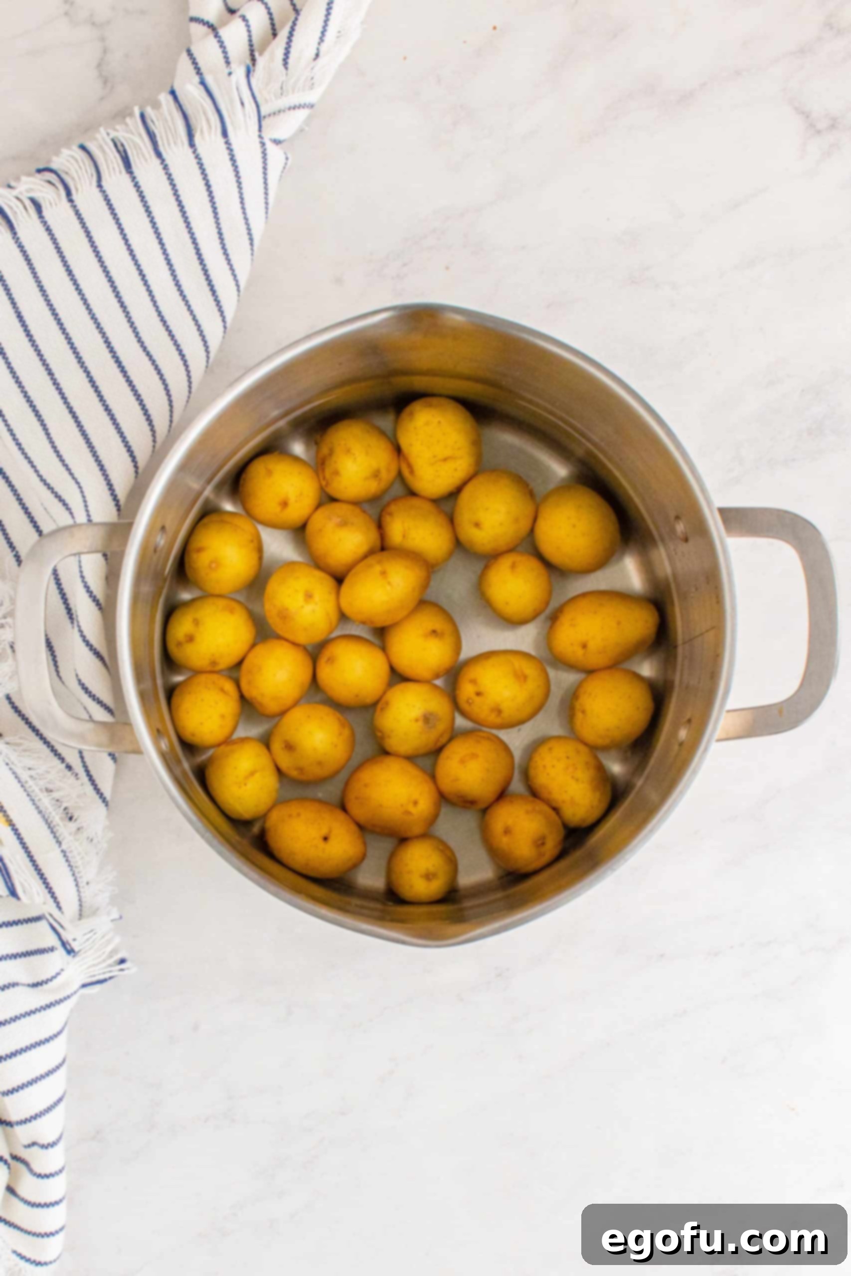 Potatoes in the bottom of a stock pot.