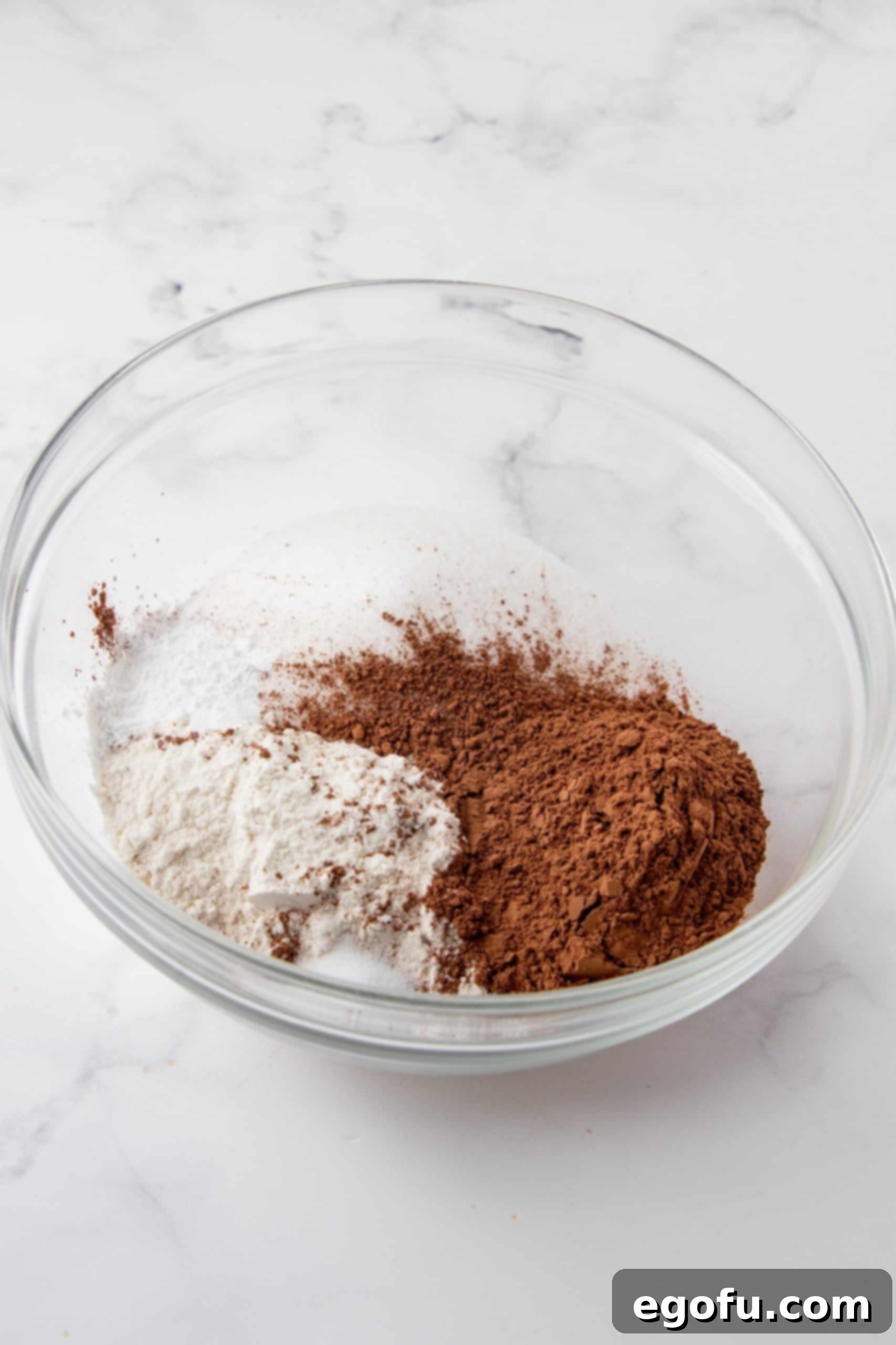 Decadent Baileys Cupcakes 5 Dry ingredients, including flour, sugar, and cocoa powder, measured out in a large mixing bowl, ready to be combined for the Baileys cupcake batter.