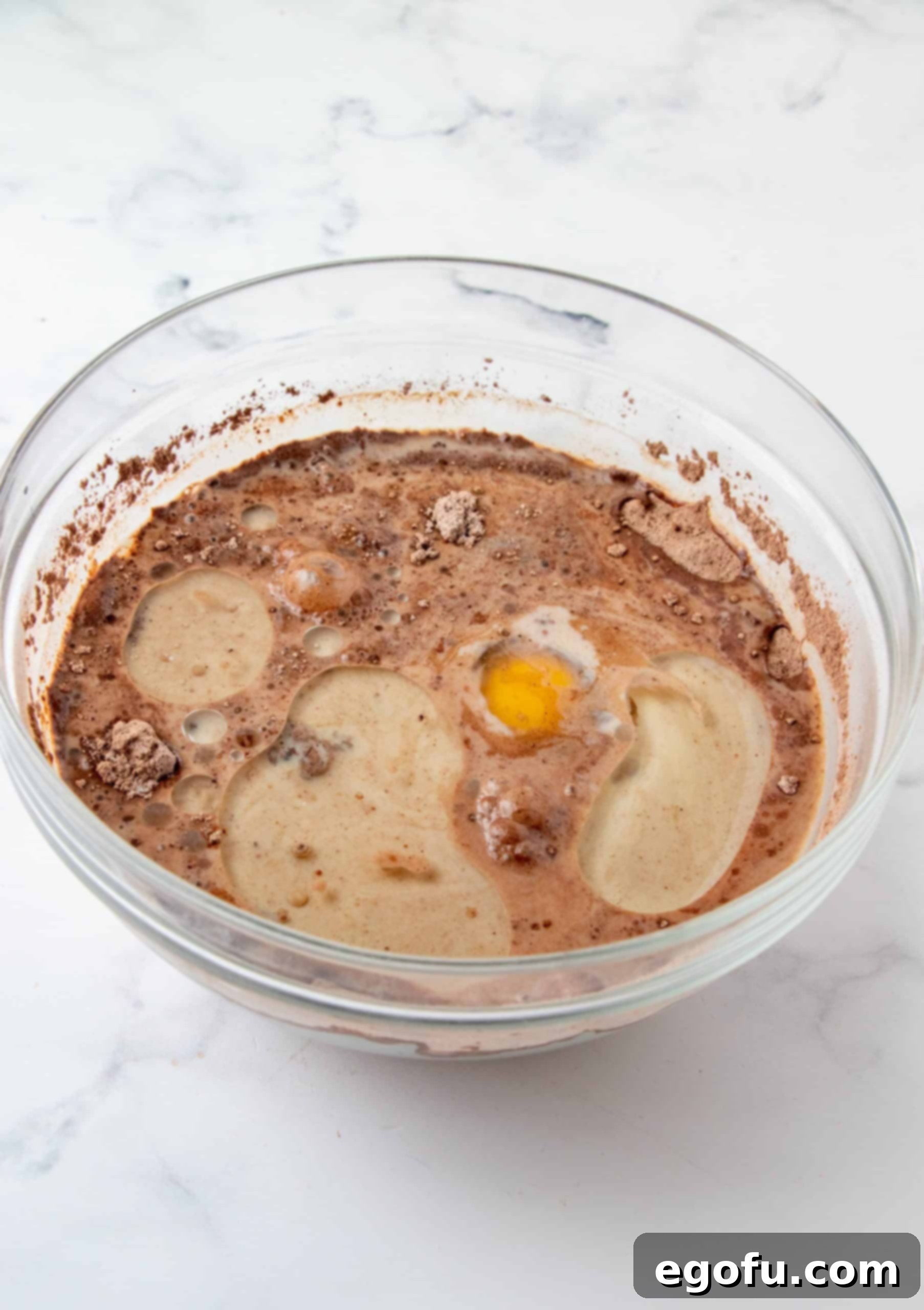 Decadent Baileys Cupcakes 7 Wet ingredients, including eggs, vanilla, Baileys Irish Cream, water, and oil, poured directly into the bowl with the whisked dry ingredients.