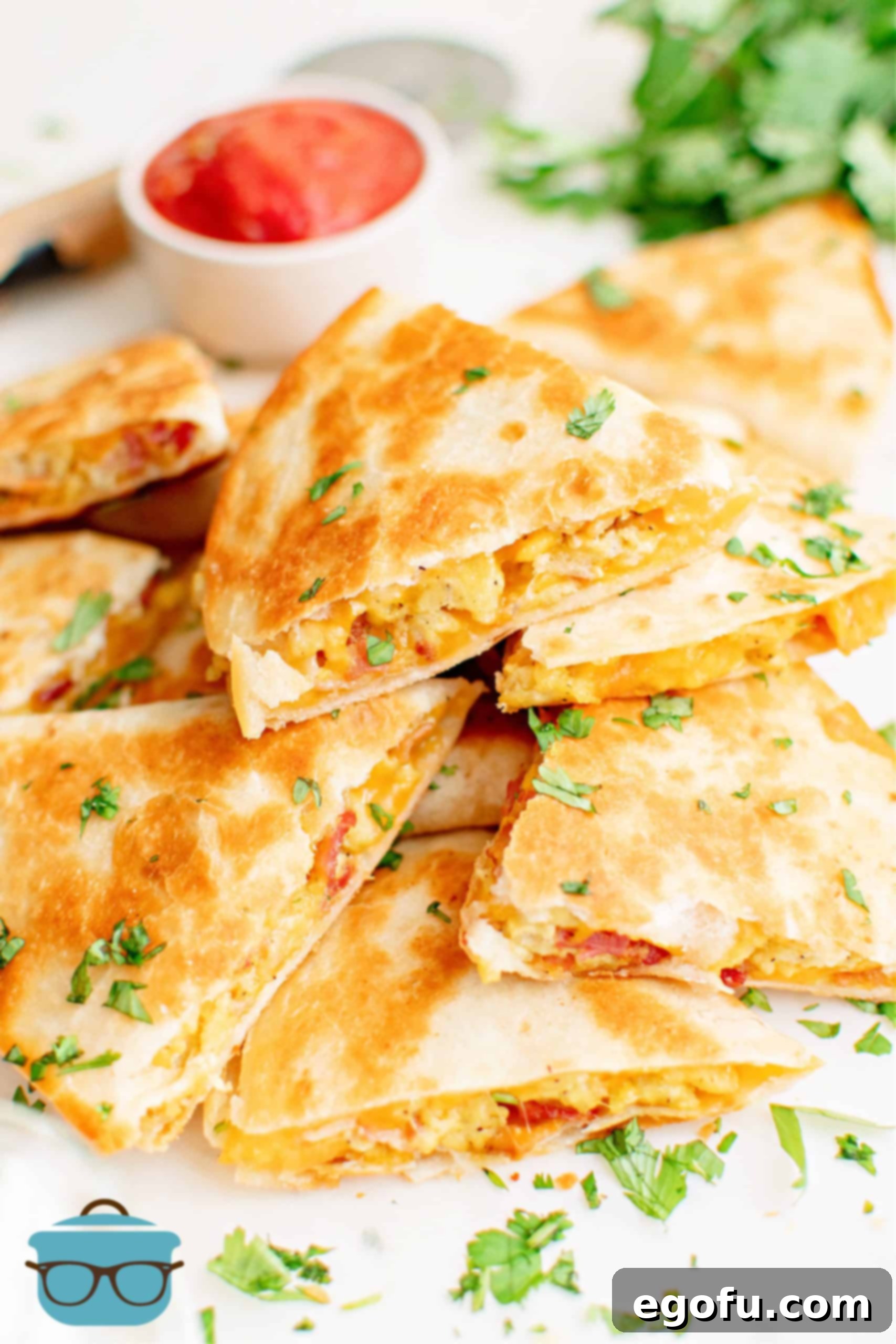 Stacked Breakfast Quesadillas with dipping sauce in background.