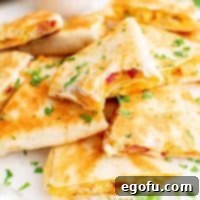 Close up of piled Breakfast Quesadillas with bite taken out of one