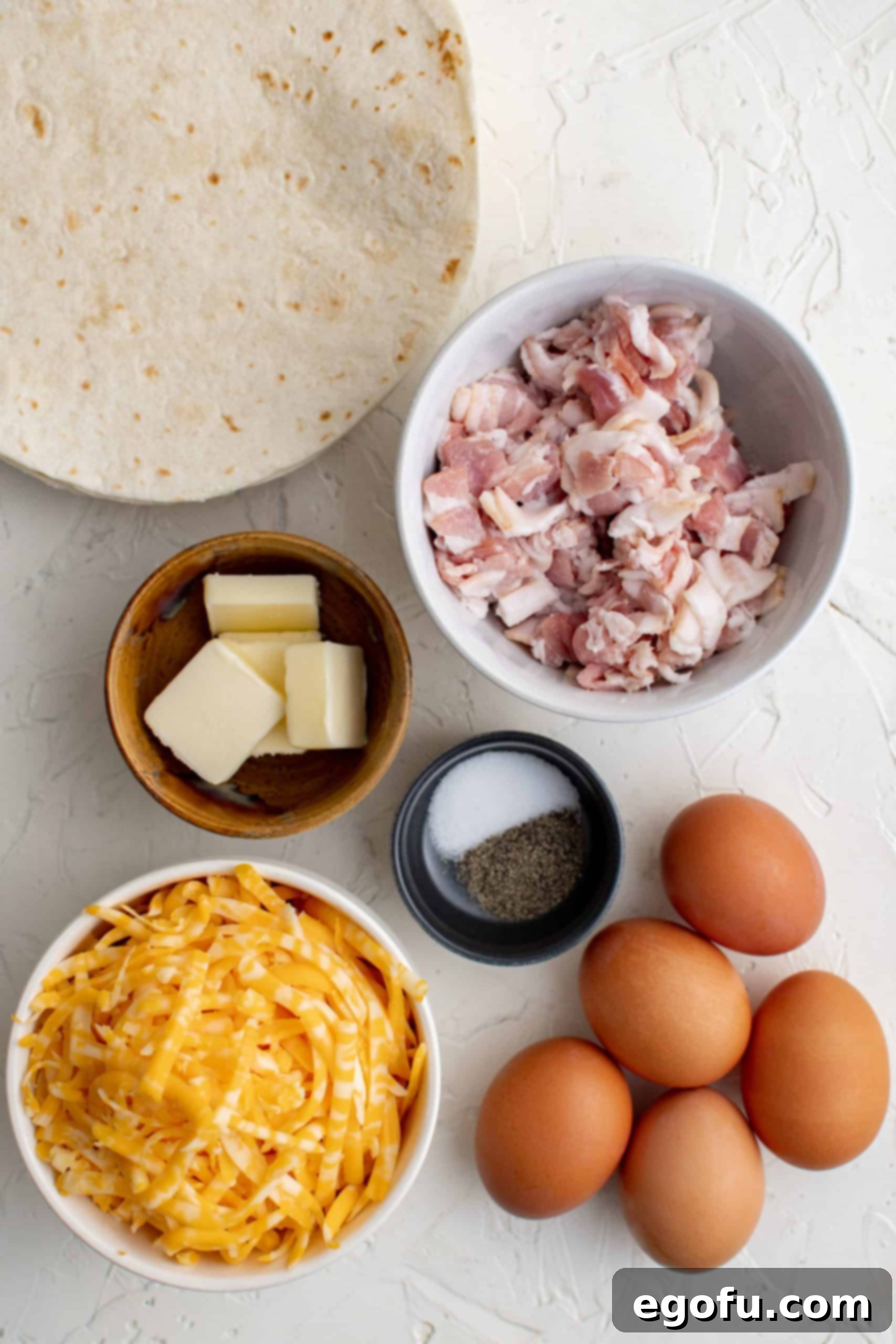 Ingredients needed to make Breakfast Quesadillas: bacon, eggs, butter, tortillas and cheese.