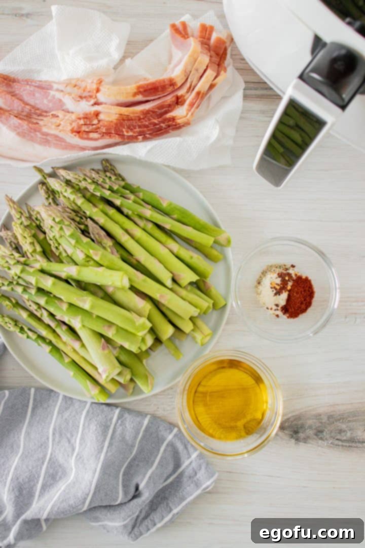 Crispy Air Fryer Bacon Asparagus Bundles 4 Ingredients needed to make Air Fryer Bacon Wrapped Asparagus: asparagus, olive oil, garlic powder, paprika, salt, pepper, red pepper flakes, bacon.