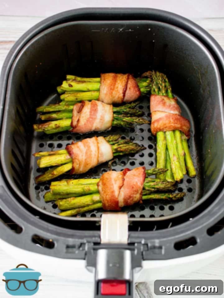Crispy Air Fryer Bacon Asparagus Bundles 9 Finished Air Fryer Bacon Wrapped Asparagus in air fryer.
