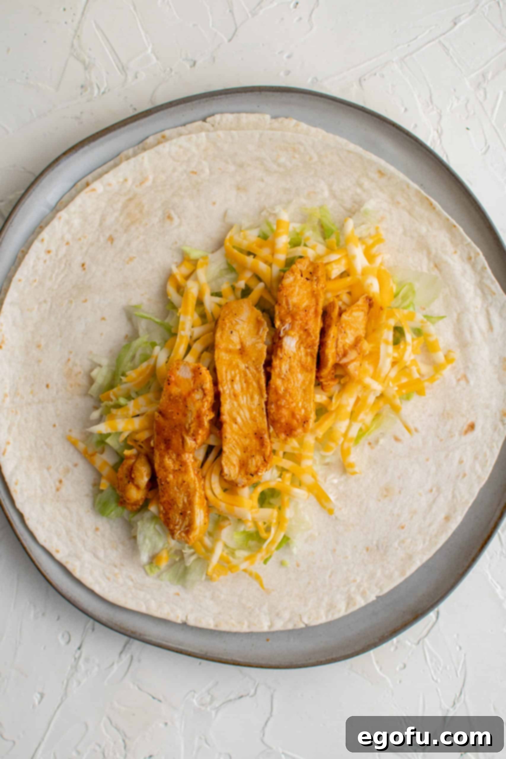 Sliced chicken on top of cheese and shredded lettuce.