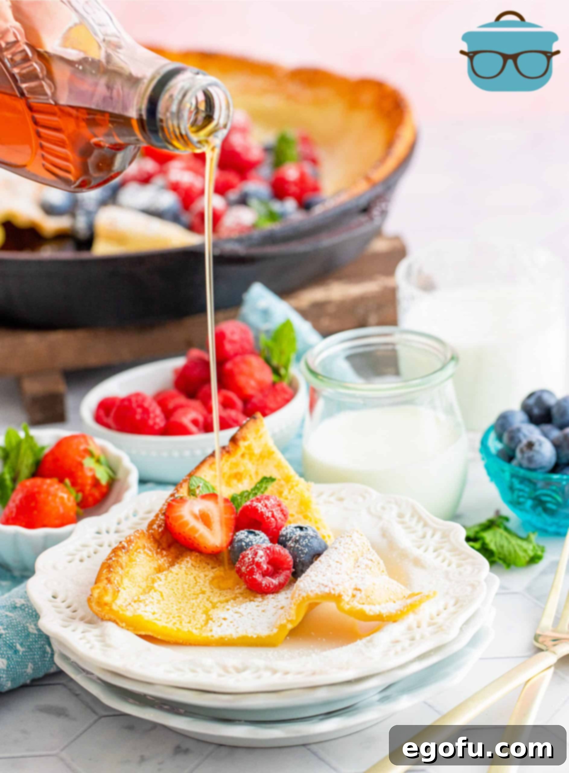 Oven Baked Cloud Pancake 9 Slice of pancake on white plate with syrup being poured over it.