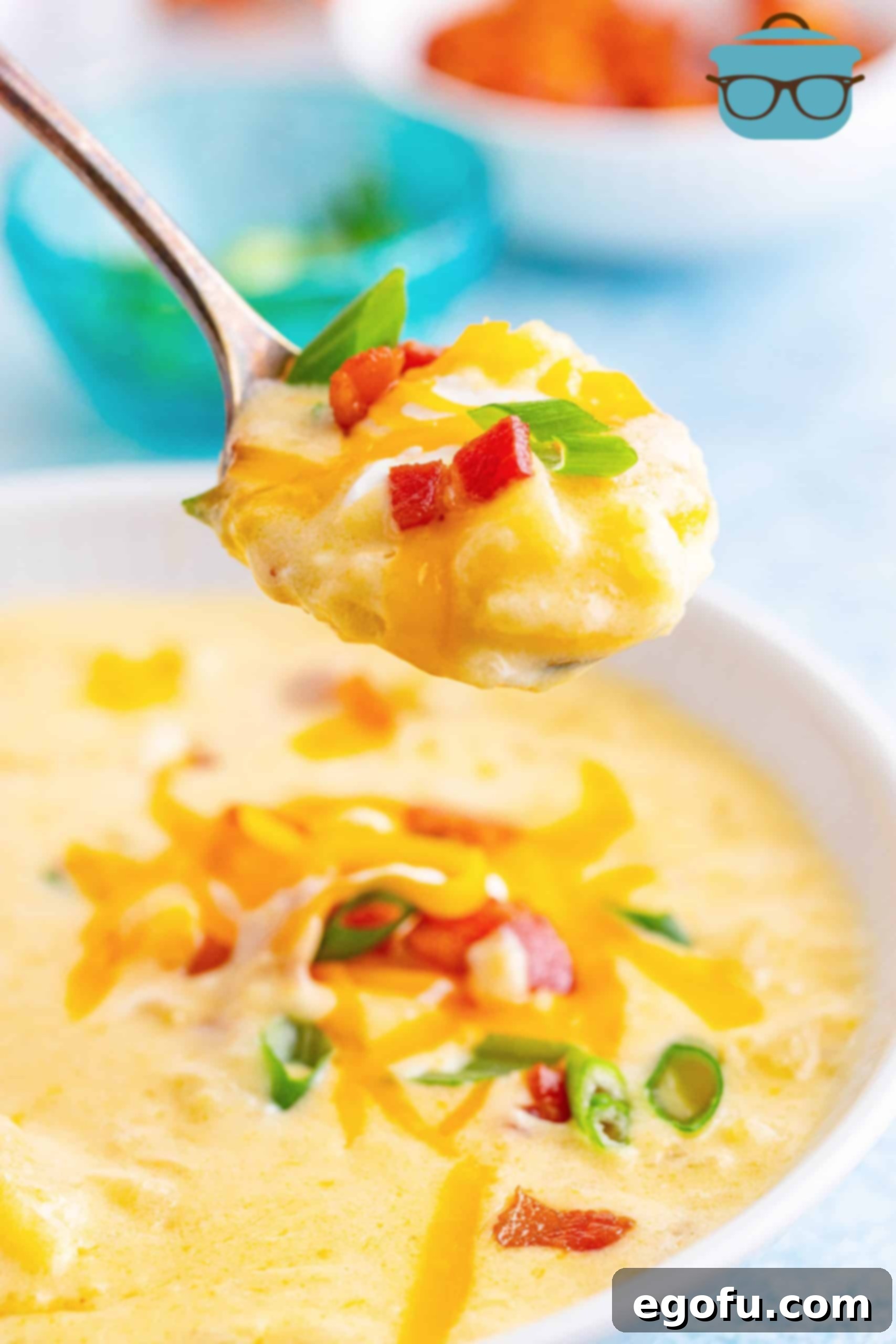 A spoon lifting a creamy portion of Instant Pot Loaded Potato Soup from a rustic bowl, garnished with bacon, cheese, and green onions.