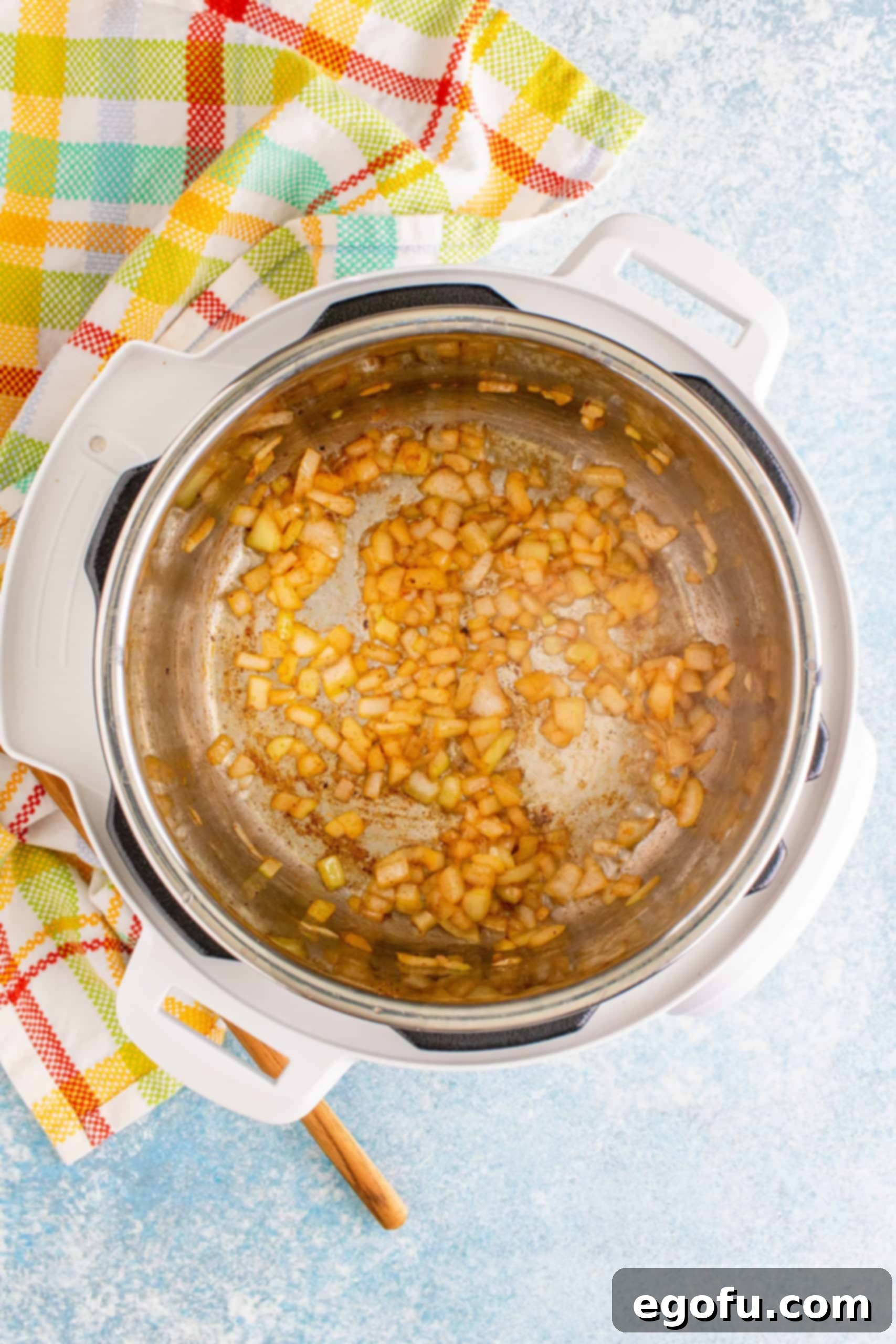 Diced onions and minced garlic sautéing in the Instant Pot after bacon has been removed.