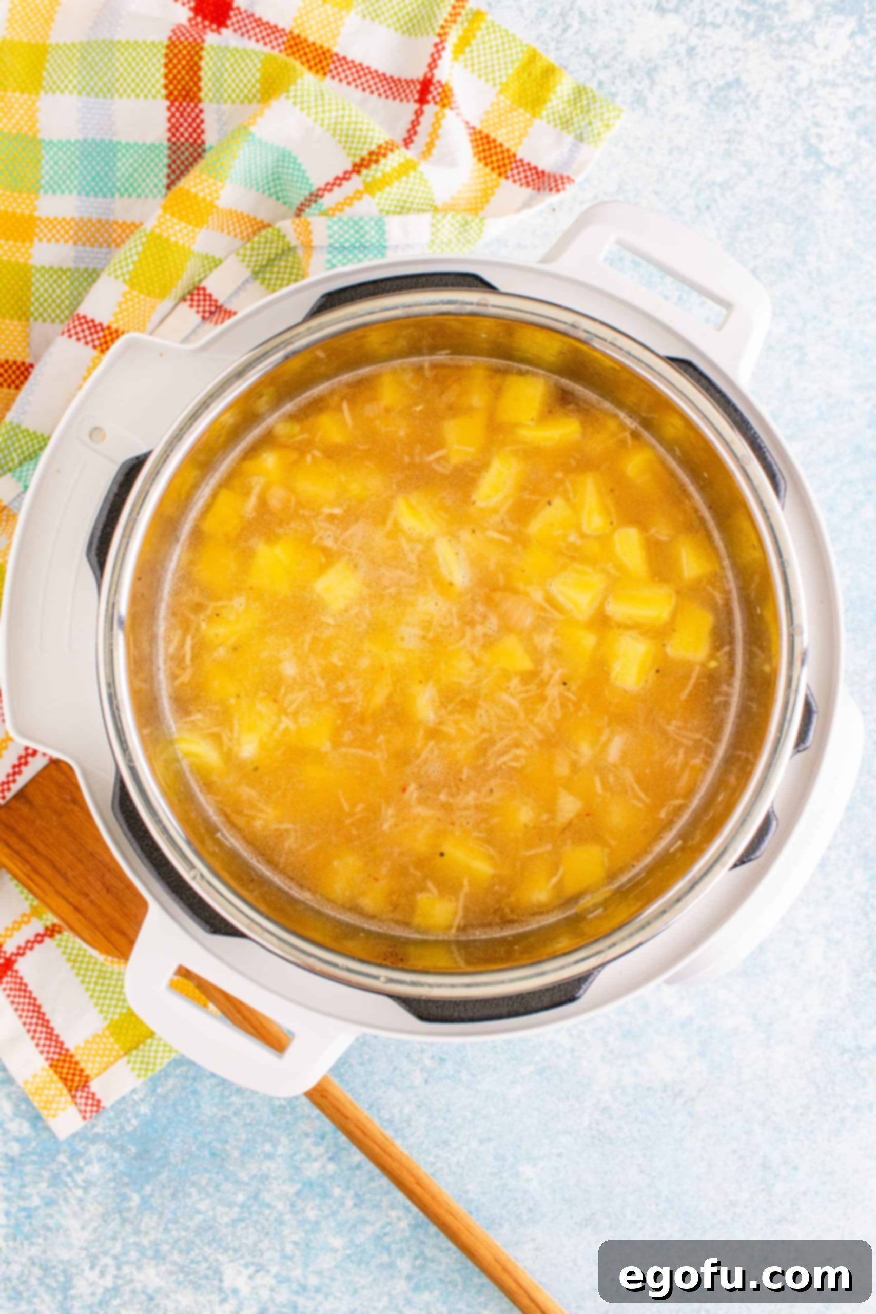 Potatoes, salt, pepper, and chicken stock added to the Instant Pot, ready for pressure cooking.
