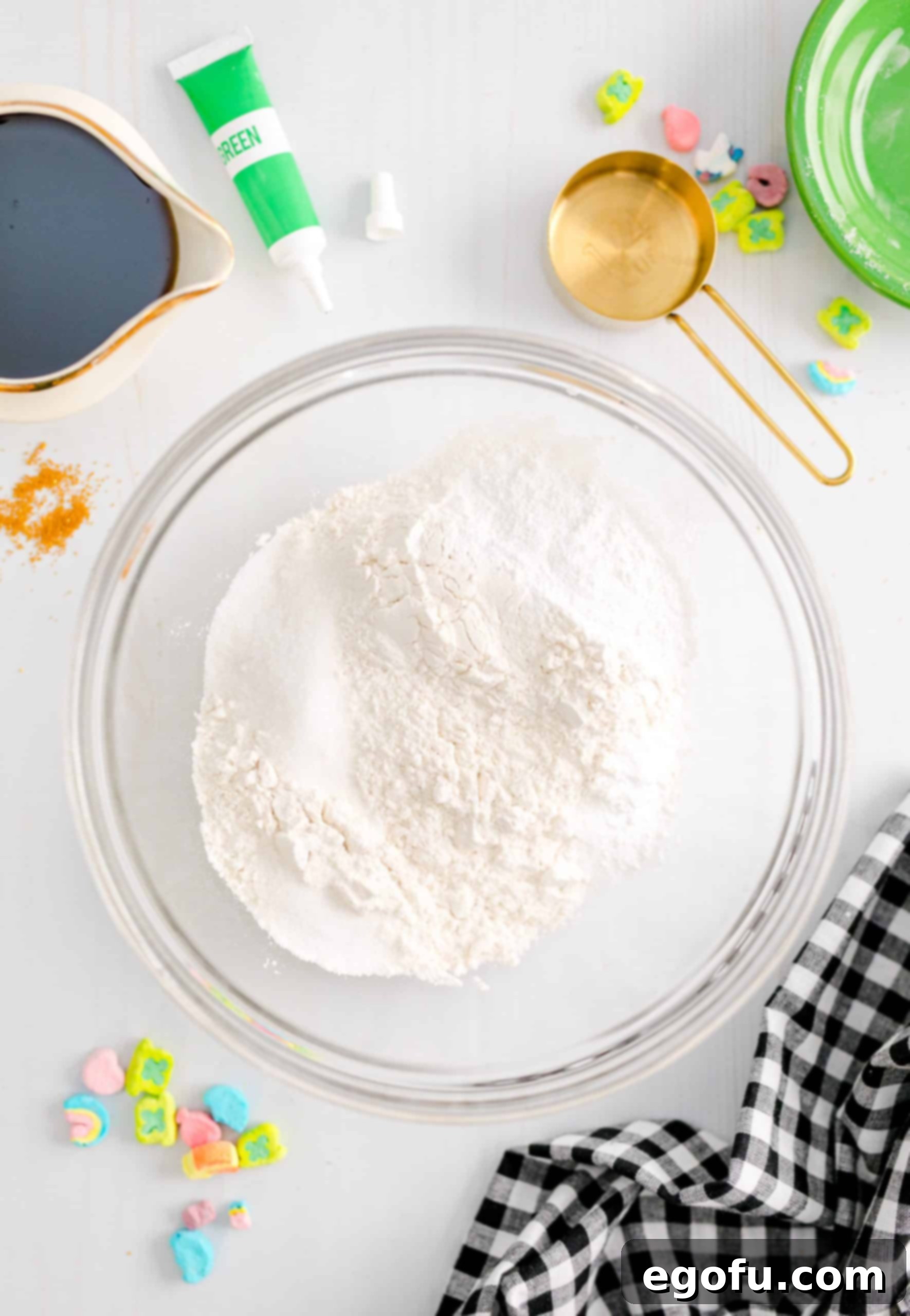 Dry ingredients, including flour, sugar, baking powder, baking soda, and salt, are measured and combined in a clear mixing bowl, ready for the next step.