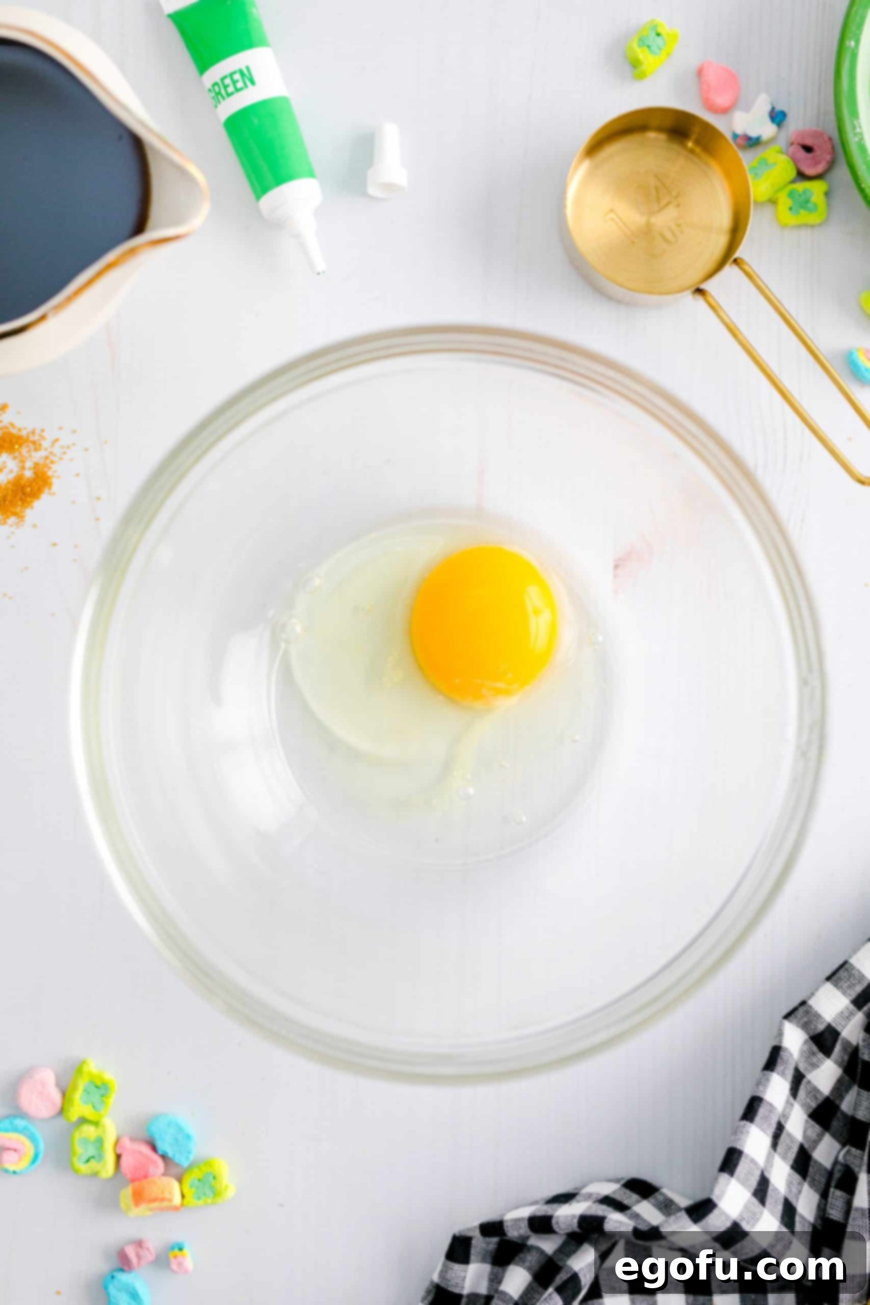 A single egg is placed in a clear medium-sized bowl, ready to be beaten thoroughly before mixing with other wet ingredients.