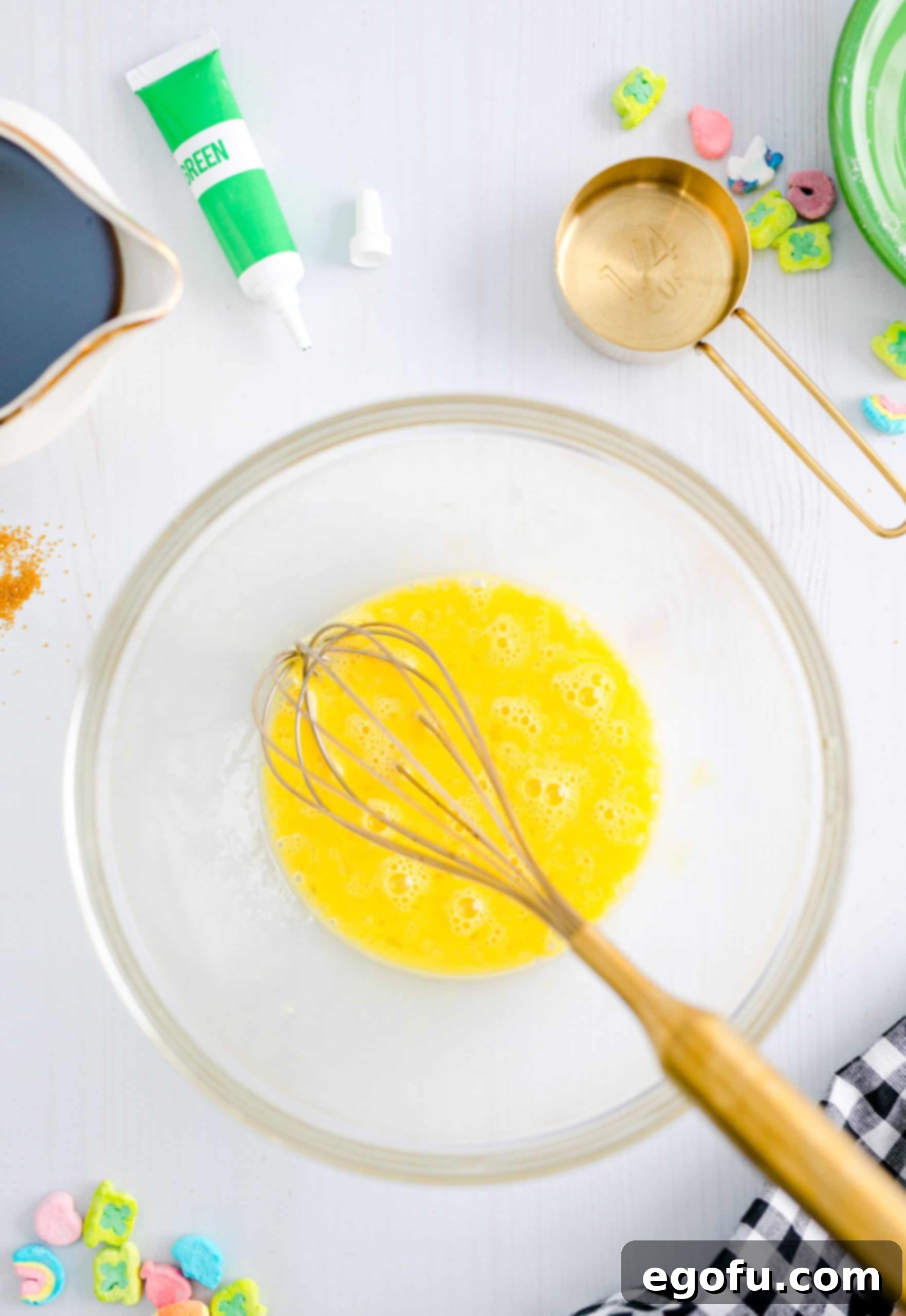 An egg being whisked vigorously in a bowl to ensure it is well beaten and airy, preparing it for the pancake batter.