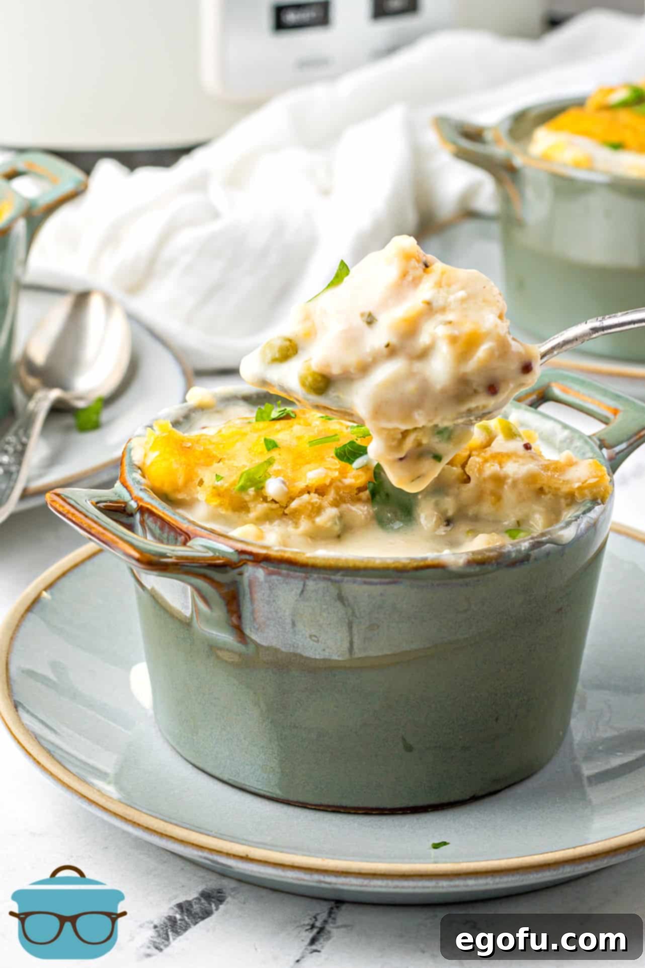 Crock Pot Chicken and Cheese Dumplings in bowl with spoon holding some up.