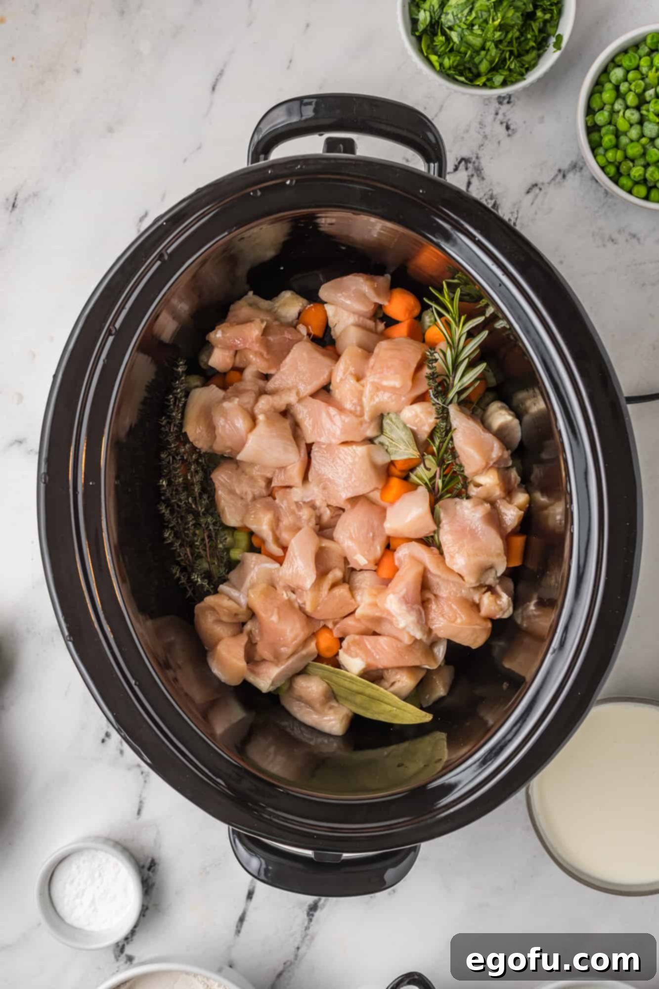 Chicken and herbs added to crock pot.