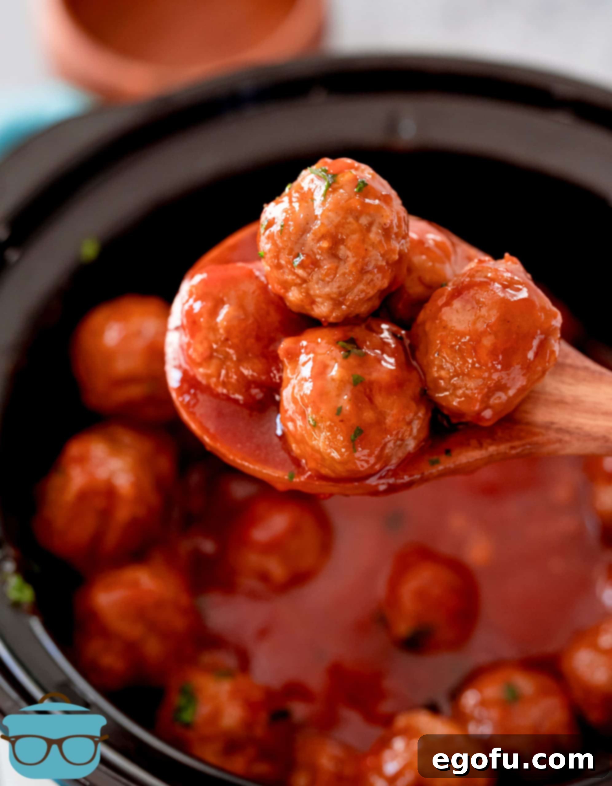 Slow Cooker Meatloaf Bites 2 Crock Pot Meatloaf Meatballs on serving spoon, showcasing the rich sauce and tender texture.