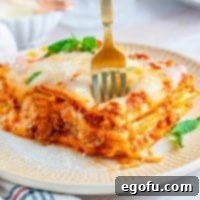 Hearty Homemade Lasagna Bake 11 Slice of Homemade Baked Lasagna on plate with fork square image
