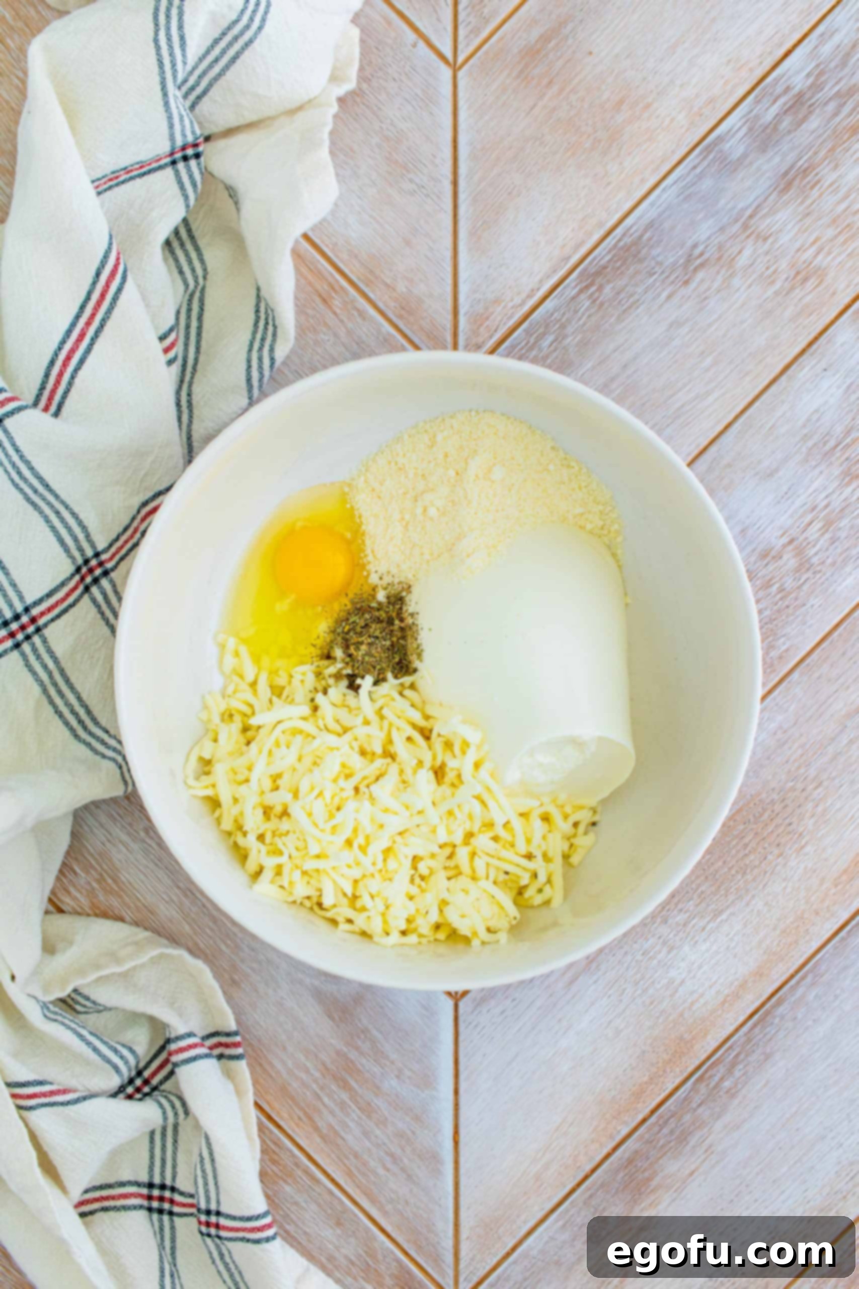 Hearty Homemade Lasagna Bake 6 Ricotta cheese, egg, parmesan and mozzarella in a white bowl.
