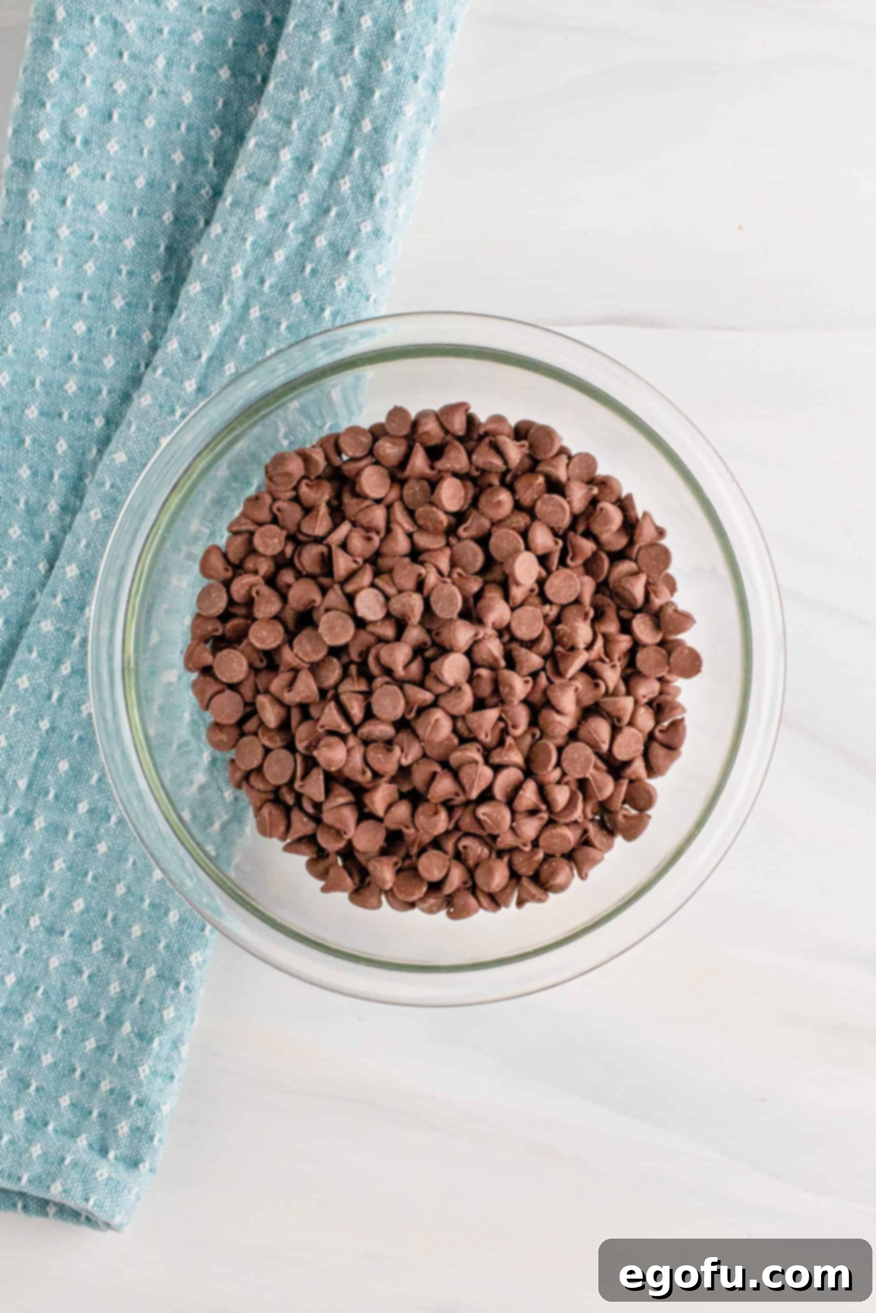 Grandma's No-Bake Peanut Butter Dream Bars 10 Semi-sweet chocolate chips in a clear glass bowl, ready to be melted for the topping.