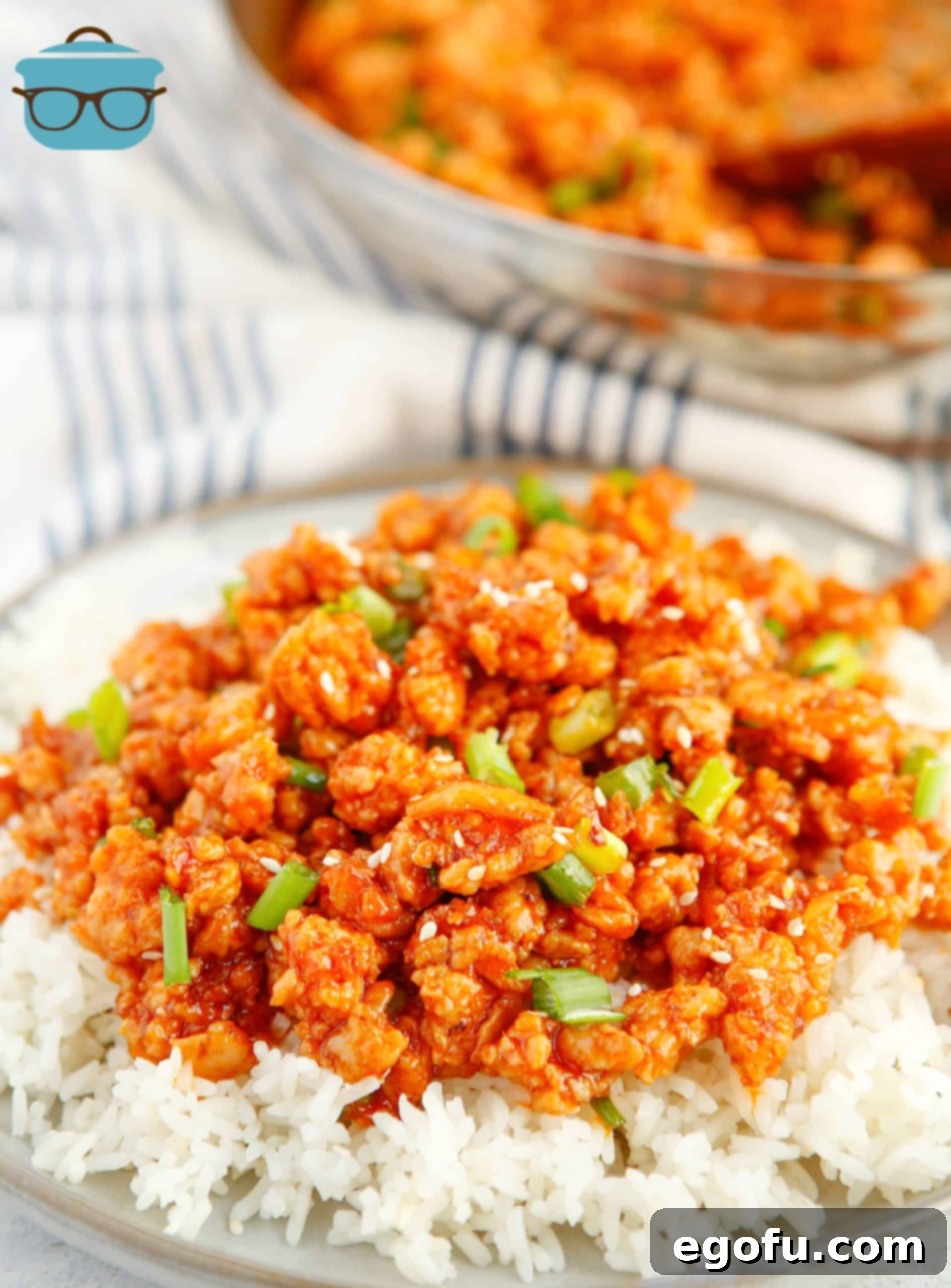 Skillet Orange Chicken Crumble 8 A beautifully plated dish of Ground Orange Chicken, served over rice and garnished with fresh green onions and sesame seeds, showcasing the rich, appetizing glaze.
