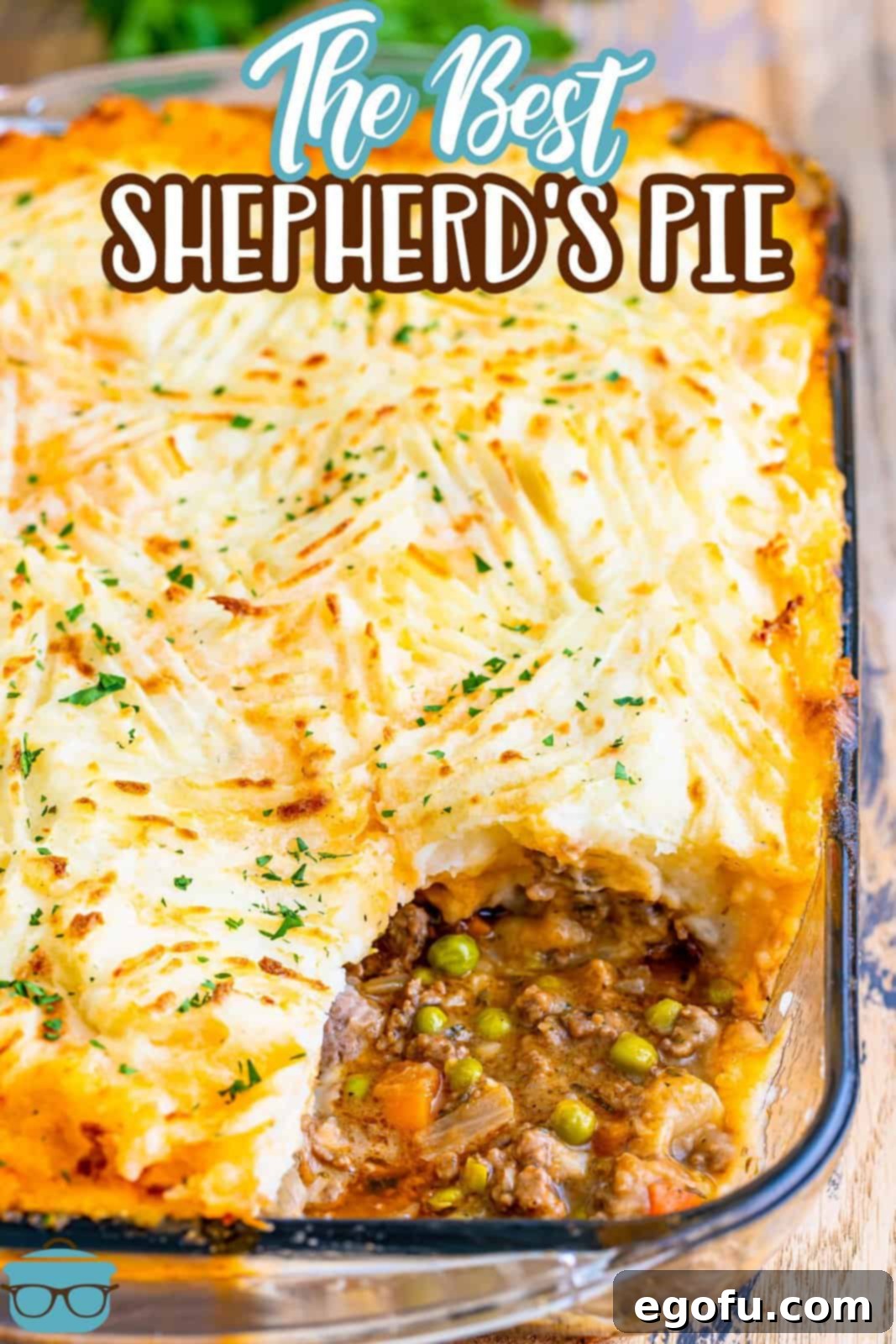 Shepherd's Pie shown baked in a clear baking dish with some of the pie removed from the bottom right corner, revealing the delicious layers.