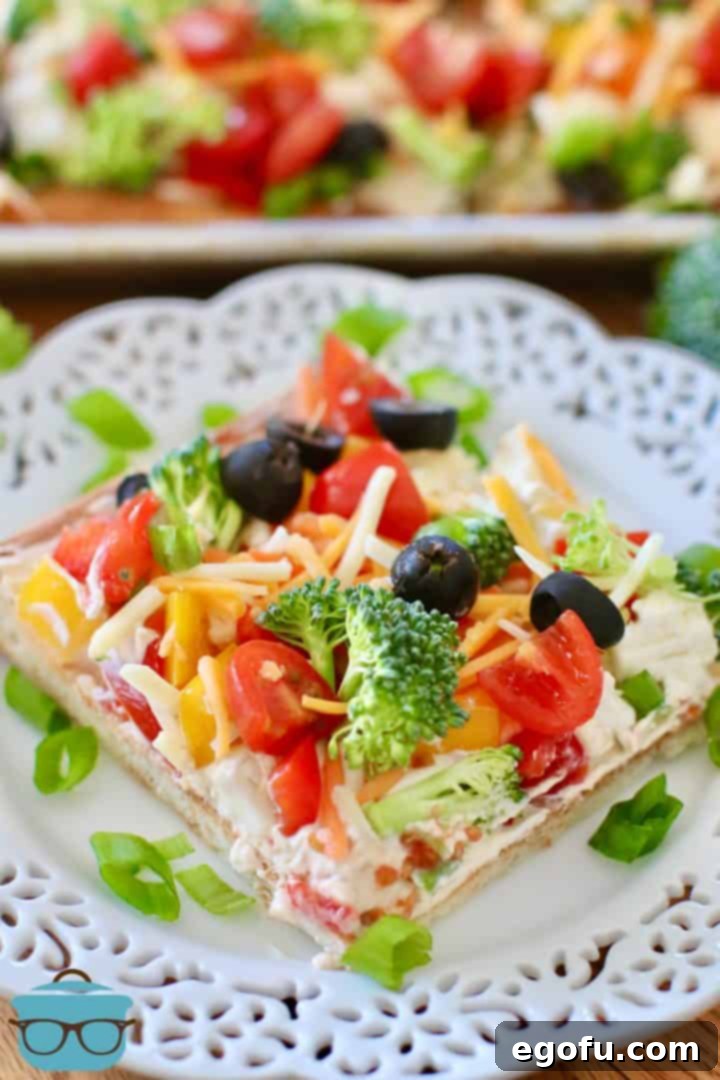 slice of vegetable cream cheese pizza on a white plate