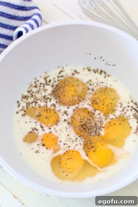 Morning Masterpiece Pizza 14 eggs, milk, salt and pepper in a white bowl