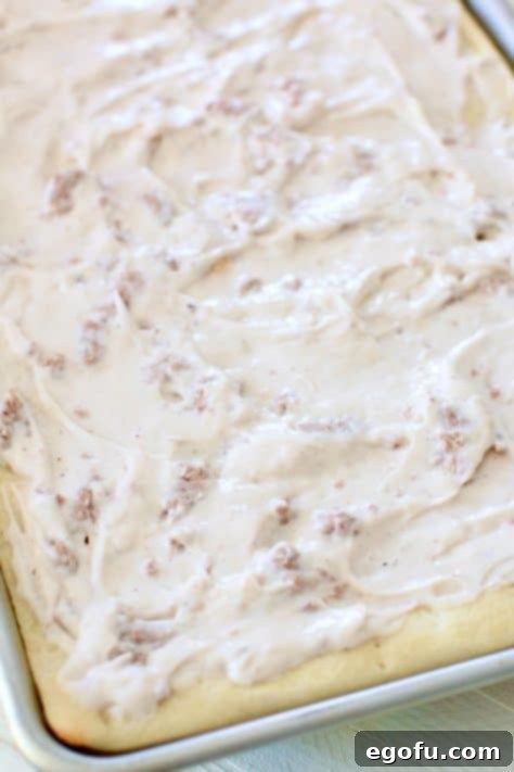 Morning Masterpiece Pizza 16 creamy white sausage gravy spread out on pizza crust in baking pan