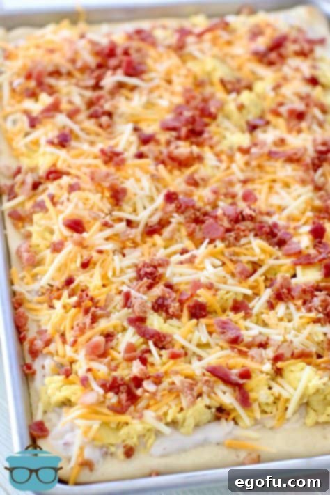 Morning Masterpiece Pizza 17 shredded cheese and bacon pieces shown on top of scrambled eggs