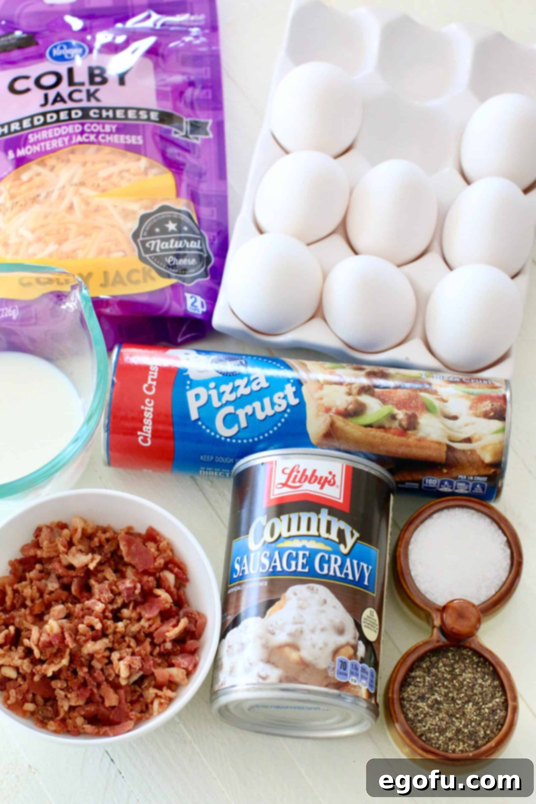 Morning Masterpiece Pizza 5 Breakfast Pizza ingredients: refrigerated pizza crust, large eggs, salt snd pepper, milk, Libby's Country Sausage Gravy, shredded Colby jack cheese, bacon pieces.