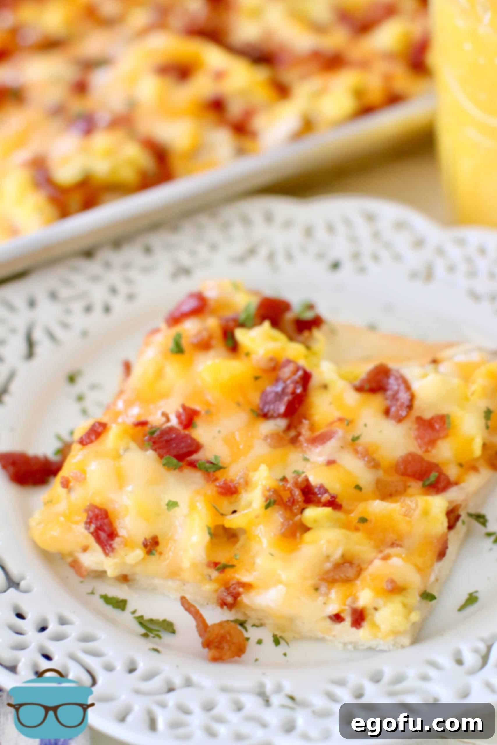 Morning Masterpiece Pizza 10 slice of bacon, egg and cheese breakfast pizza shown on a small white plate.