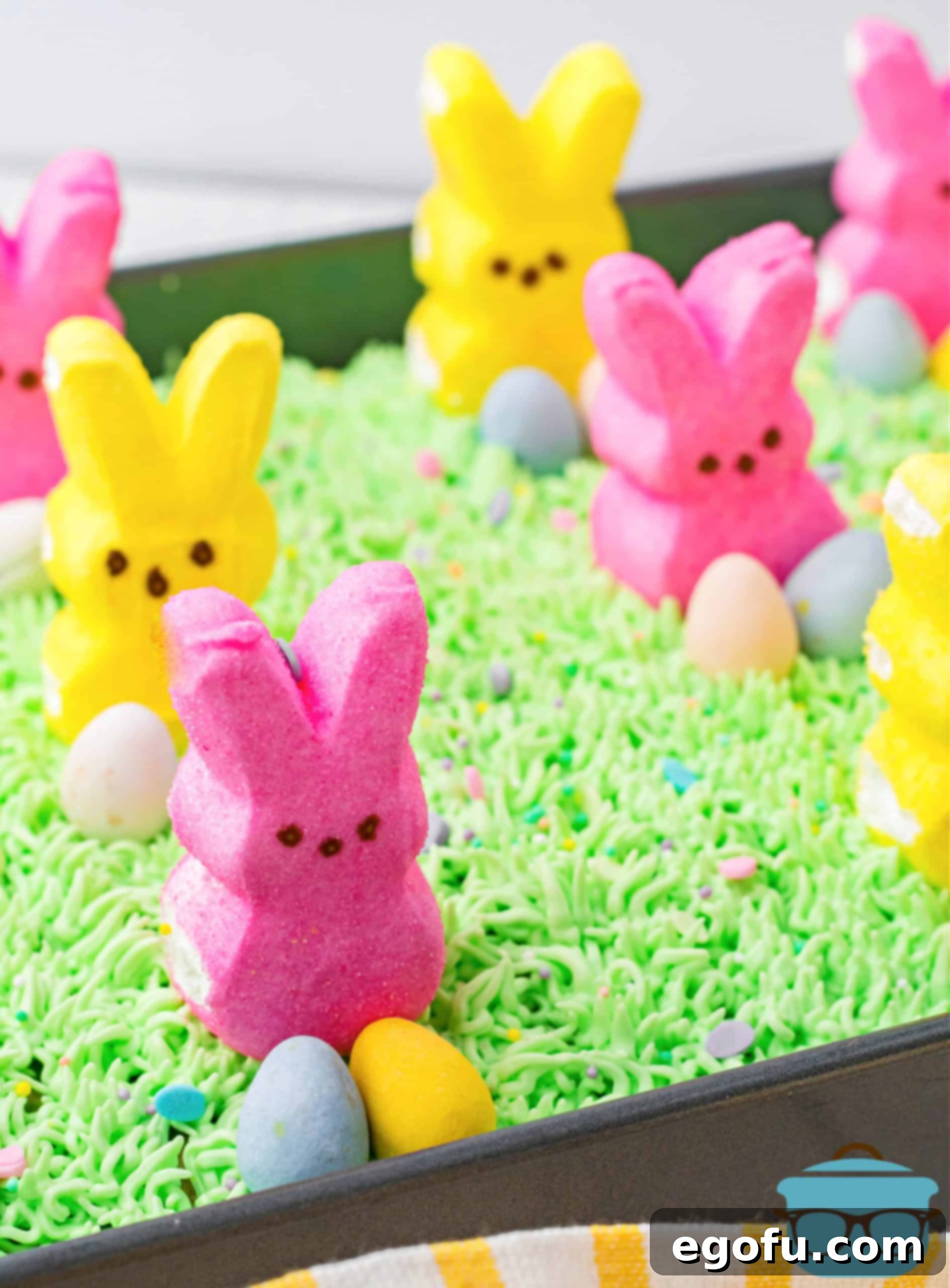 Finished Easter Bunny Poke Cake topped with bunny peeps and mini Cadbury eggs.