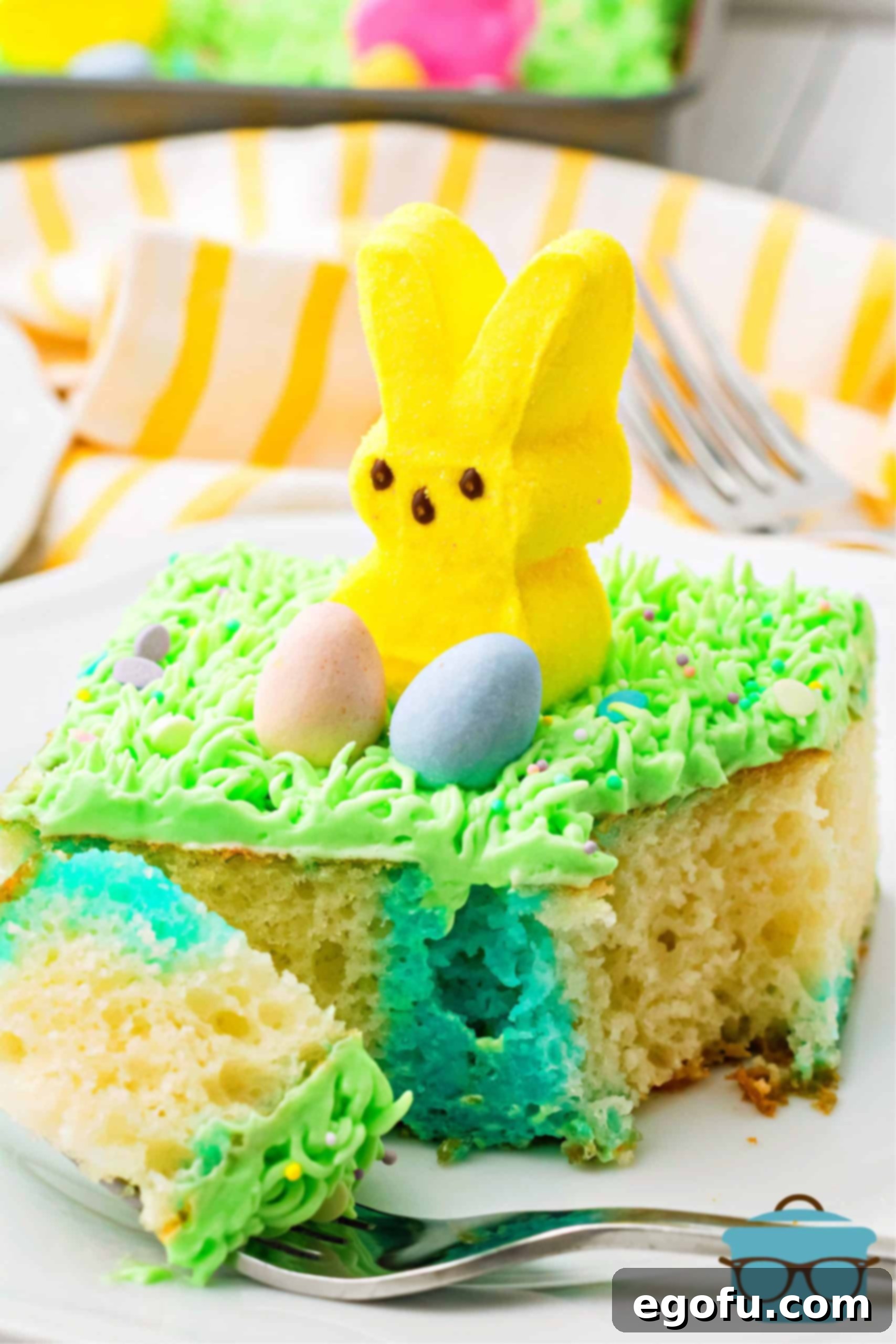 Slice of Easter Bunny Poke Cake Recipe on plate with bite taken out.