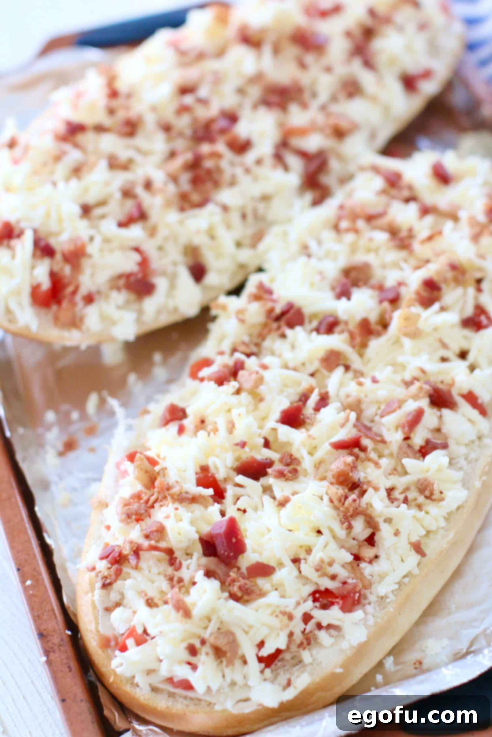 bacon pieces shown on cheese covered Italian bread.