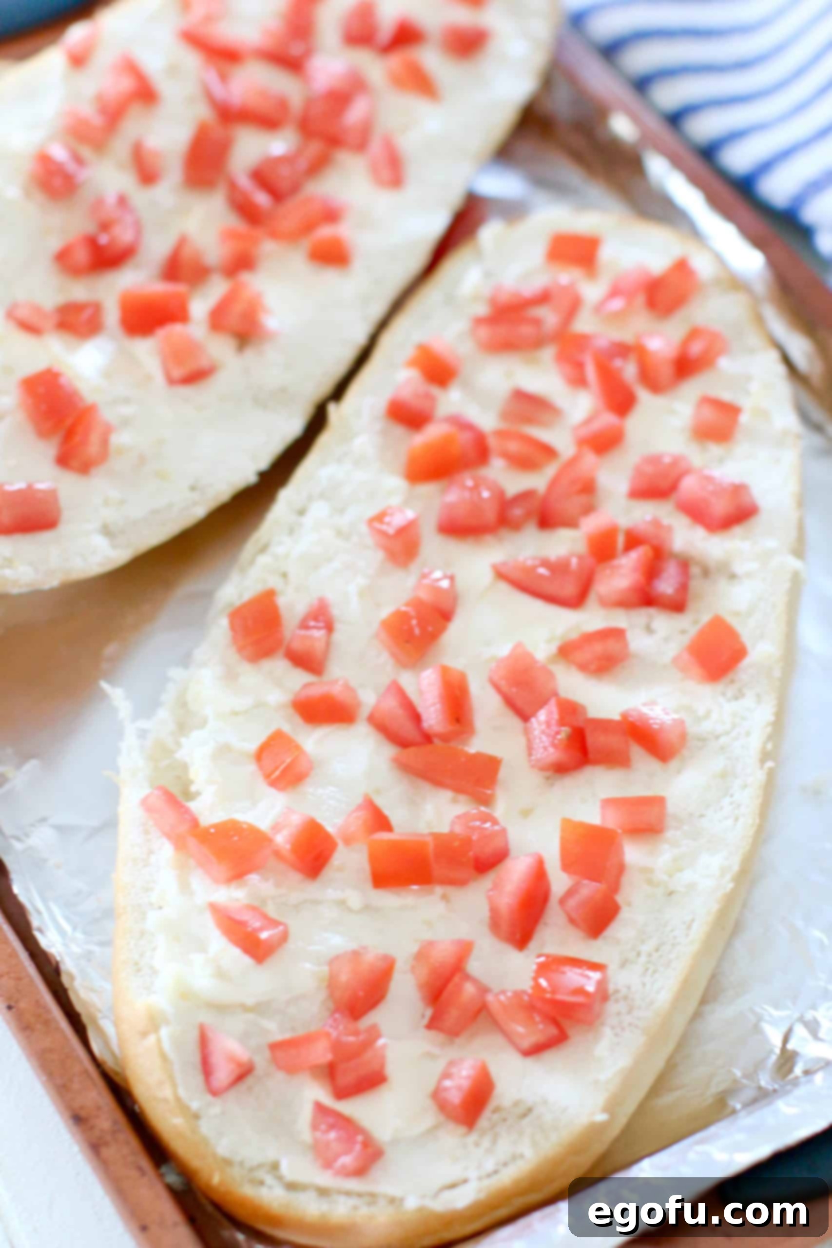 diced tomatoes shown on top of buttered bread.