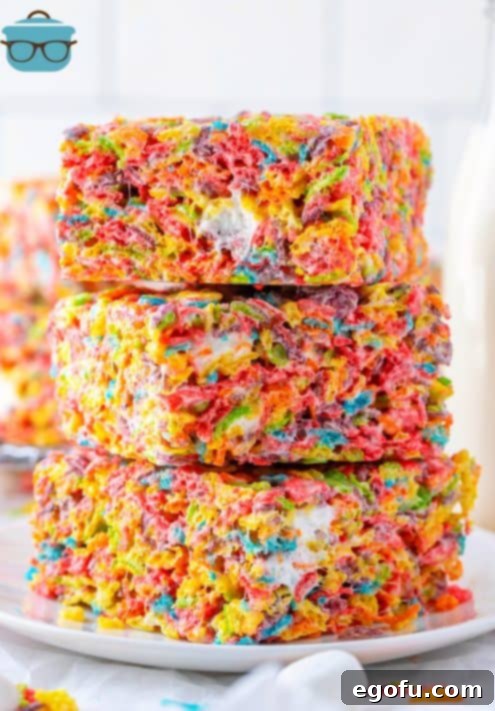 Three stacked Fruity Pebbles Treats on white plate